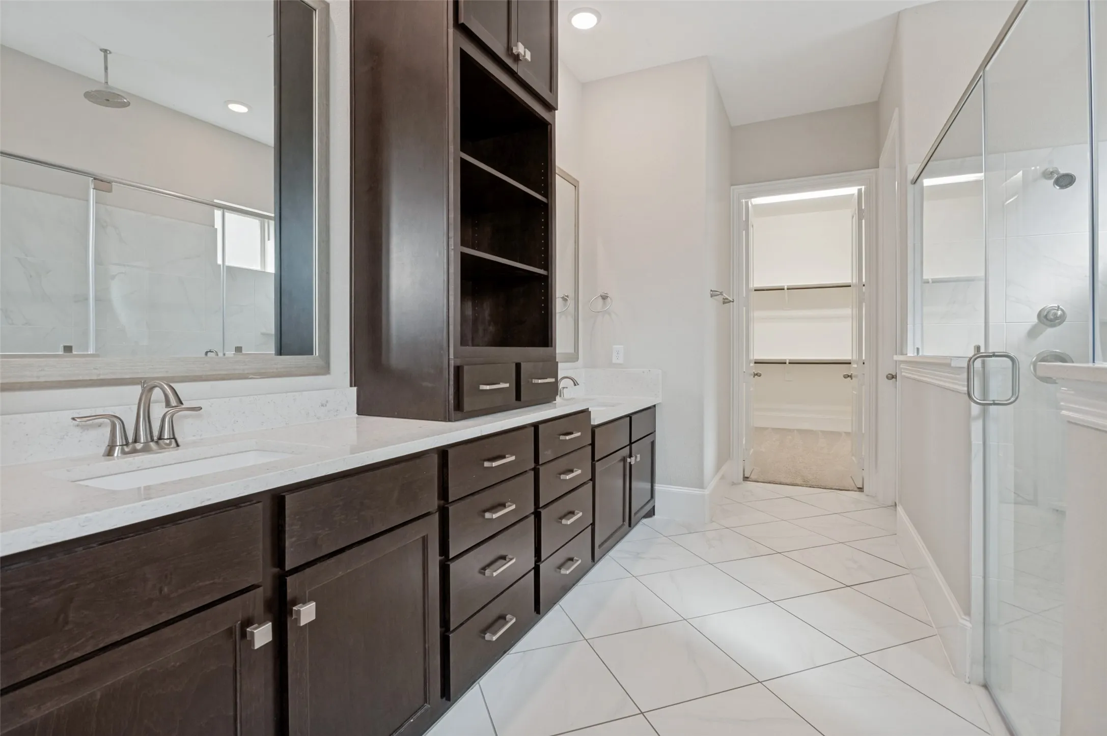 Dual vanity featuring white countertops and dark wood cabinetry with brushed nickel hardware