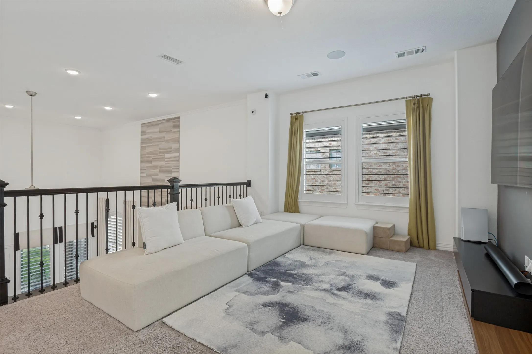 Spacious loft area featuring carpeting, recessed lighting, and a decorative accent wall