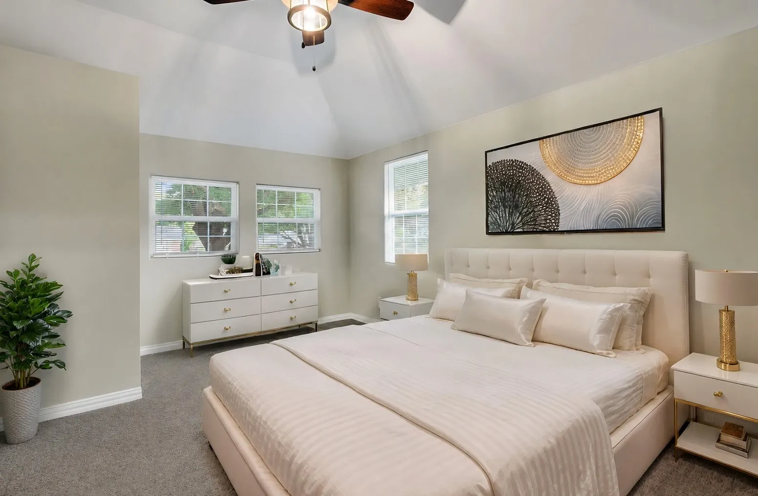 Vaulted ceiling bedroom featuring carpeting, ceiling fan, and two windows
