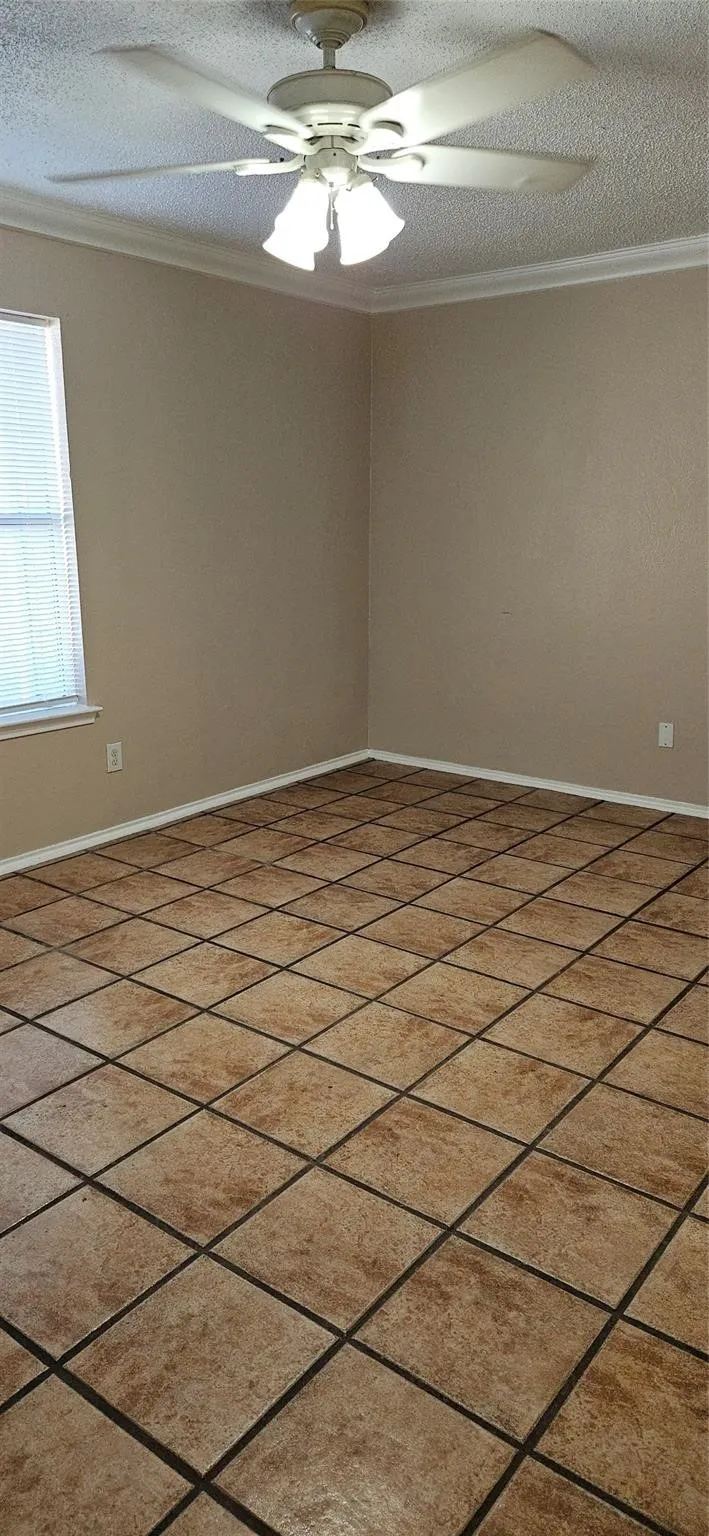 Spacious room featuring large format tile flooring, neutral wall paint, and white trim