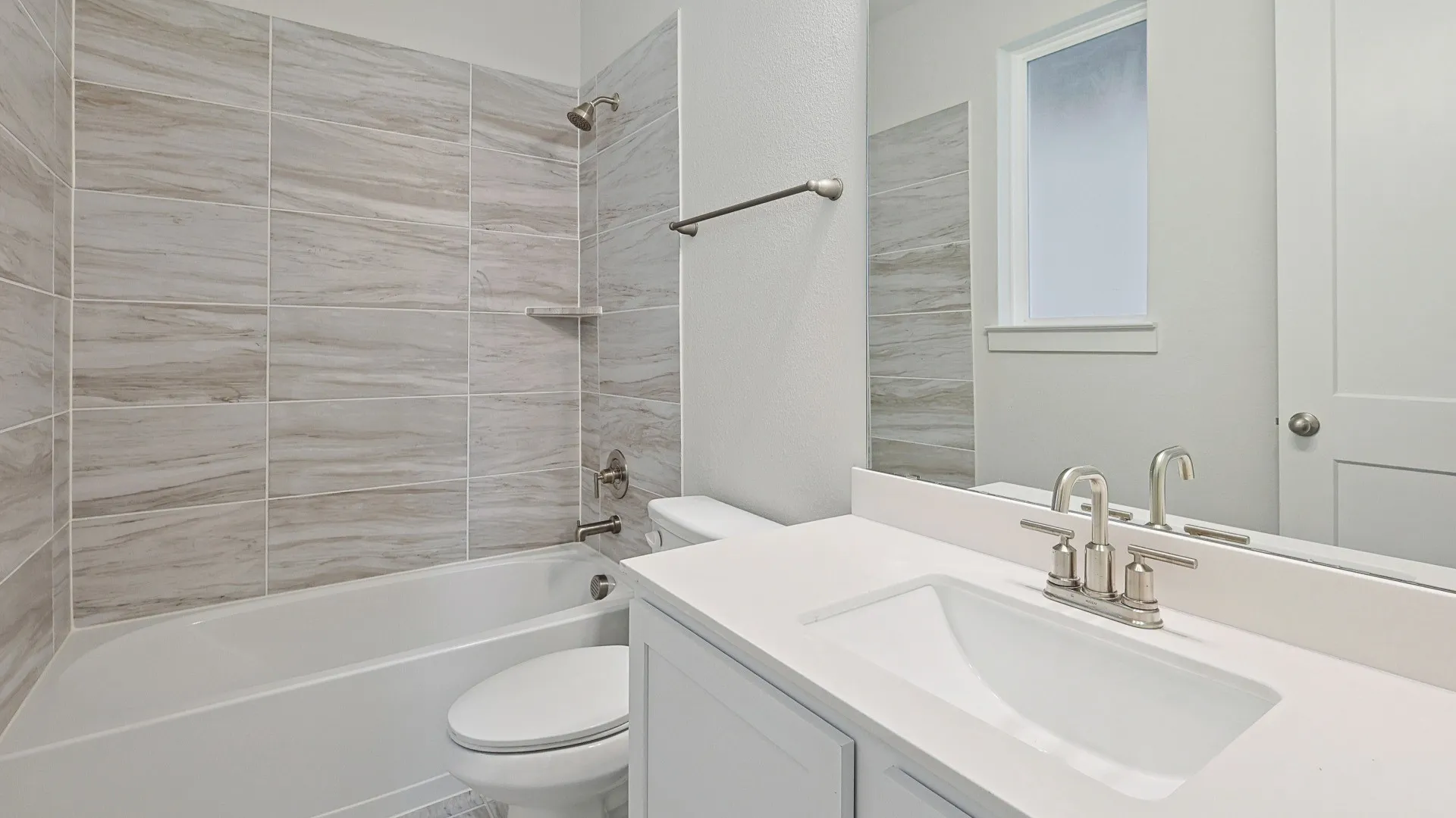 Bathroom featuring a white vanity with an integrated sink, brushed nickel faucet, and a large wall mirror