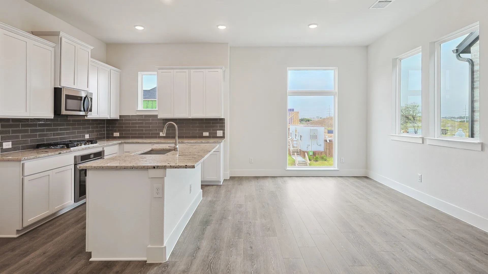 Open-concept kitchen and living area featuring wood-finish flooring