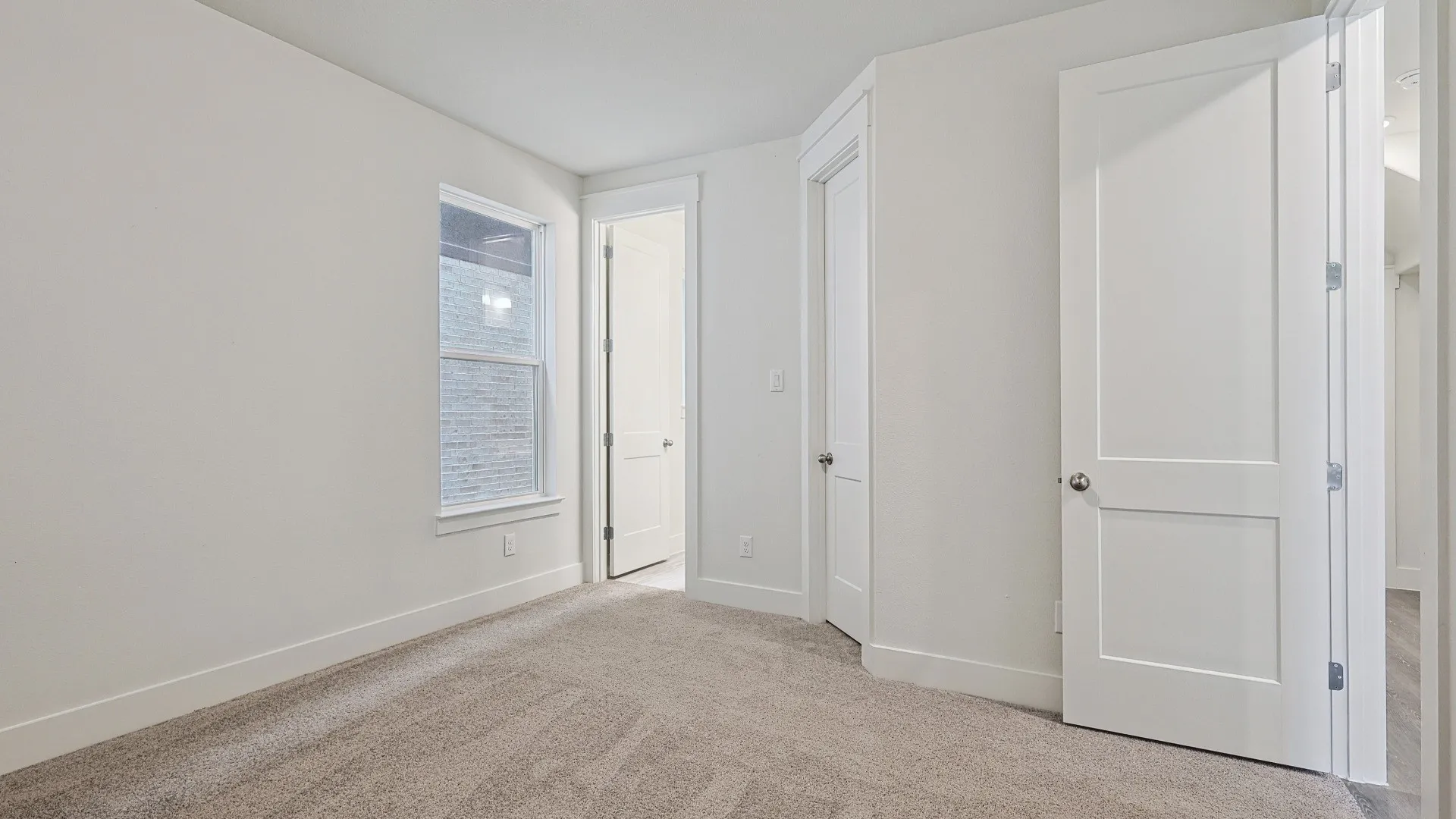 Neutral-toned carpeting paired with white baseboards and walls