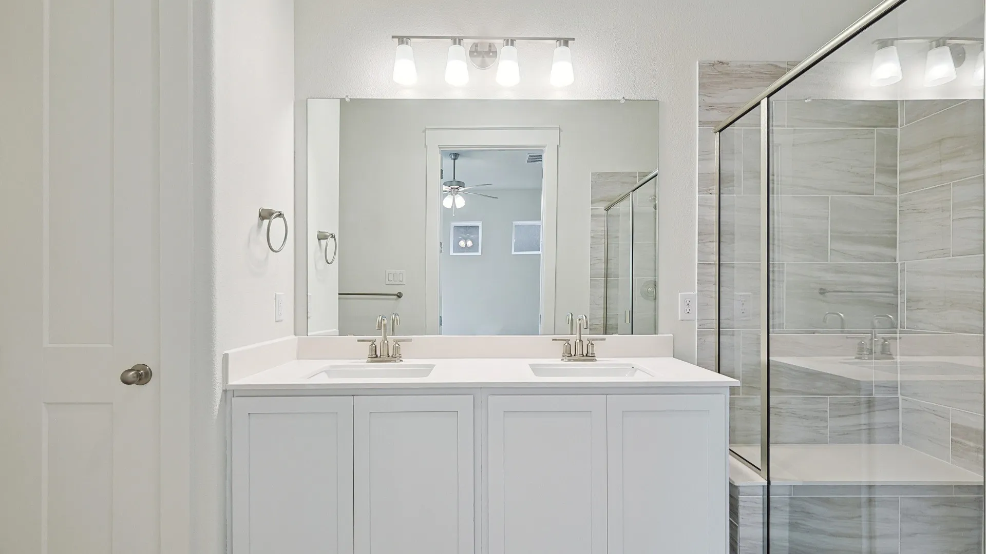 White shaker-style dual vanity with undermount sinks and a light-toned countertop