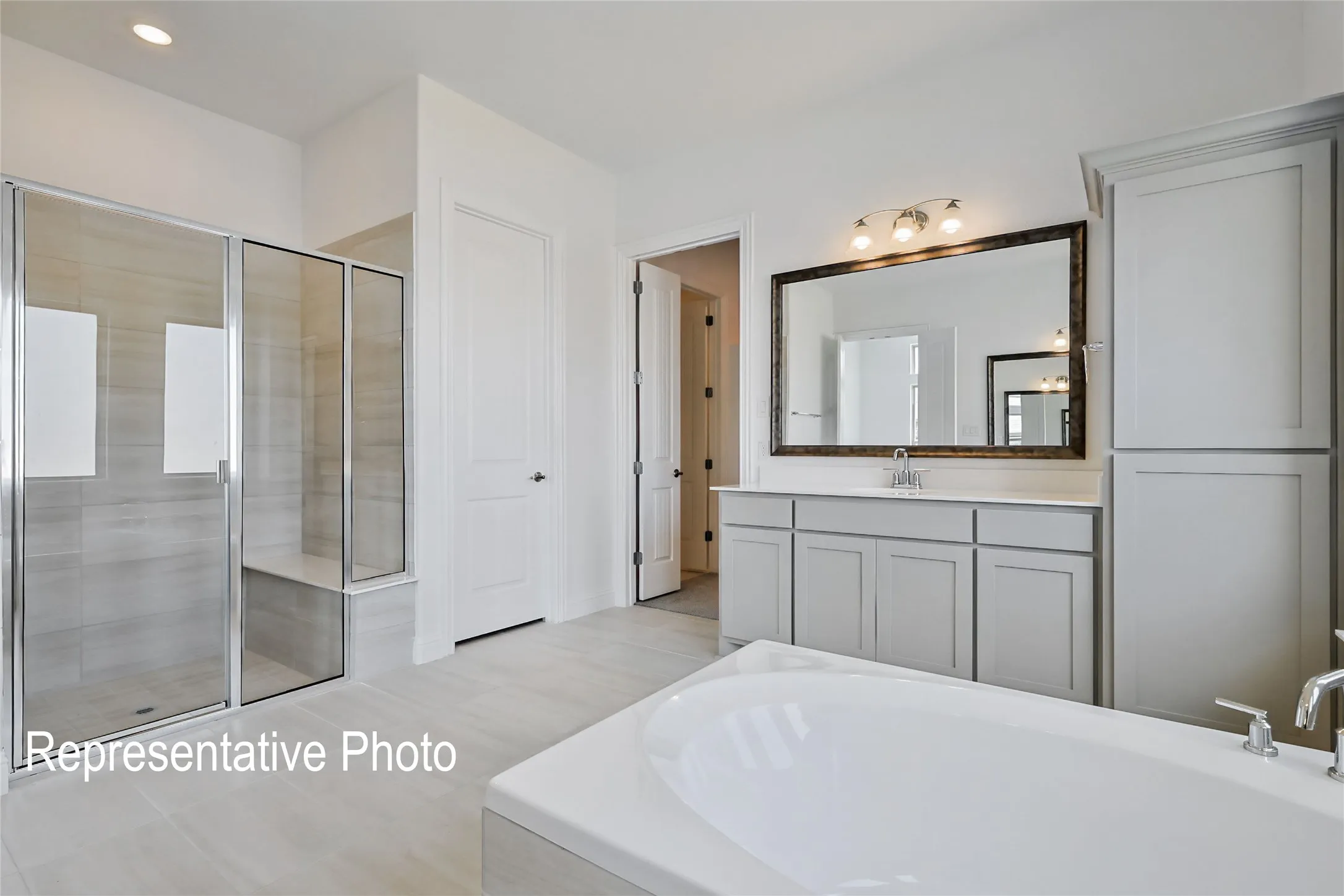 Freestanding soaking tub complemented by a spacious glass-enclosed shower with a built-in bench
