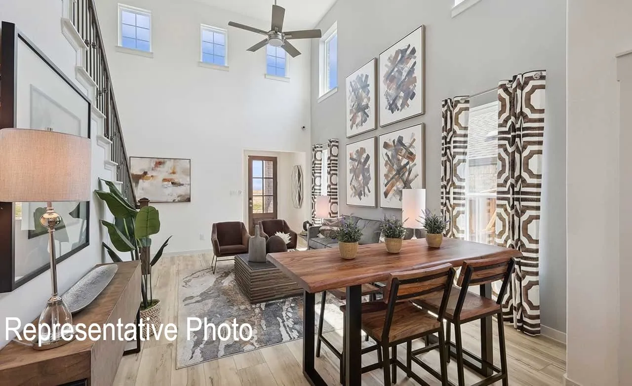 Two-story living area featuring a vaulted ceiling and an upper-level window array