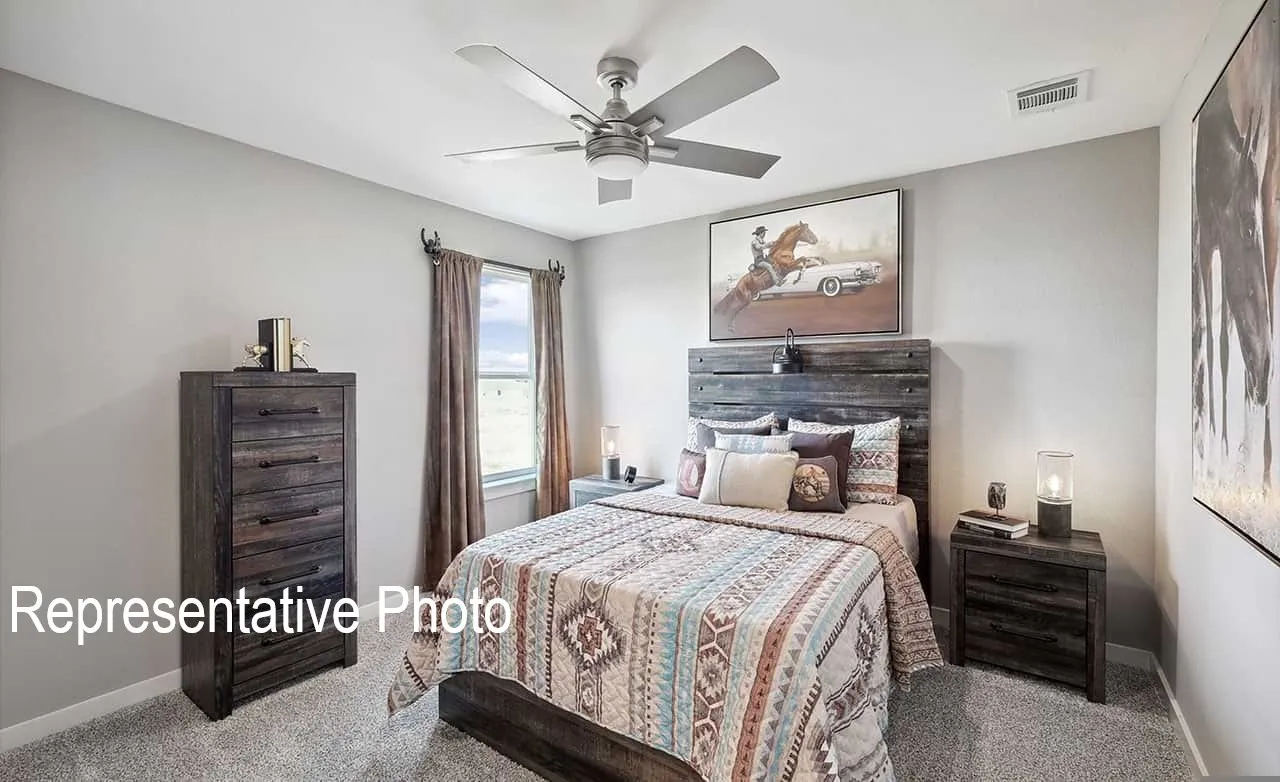 Bedroom featuring light gray walls, gray carpet flooring, a window with drapery, a ceiling fan with integrated lighting, and a rustic wood-finish headboard