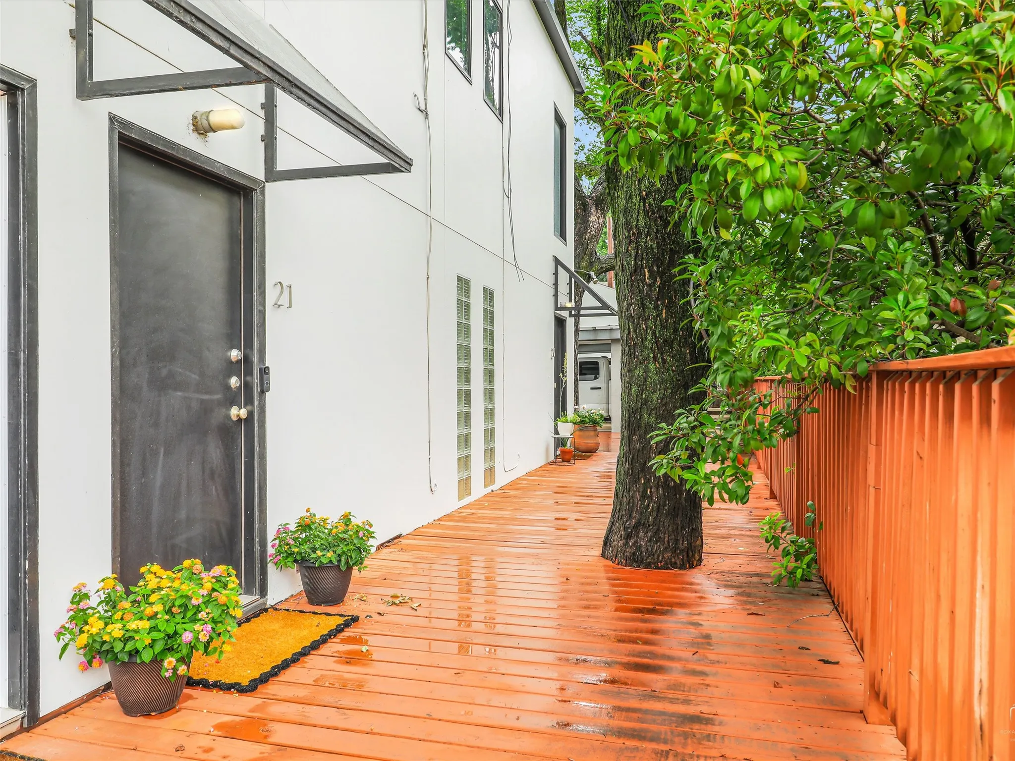 Front Entryway featuring a black door, exterior wall light fixture, and a black awning
