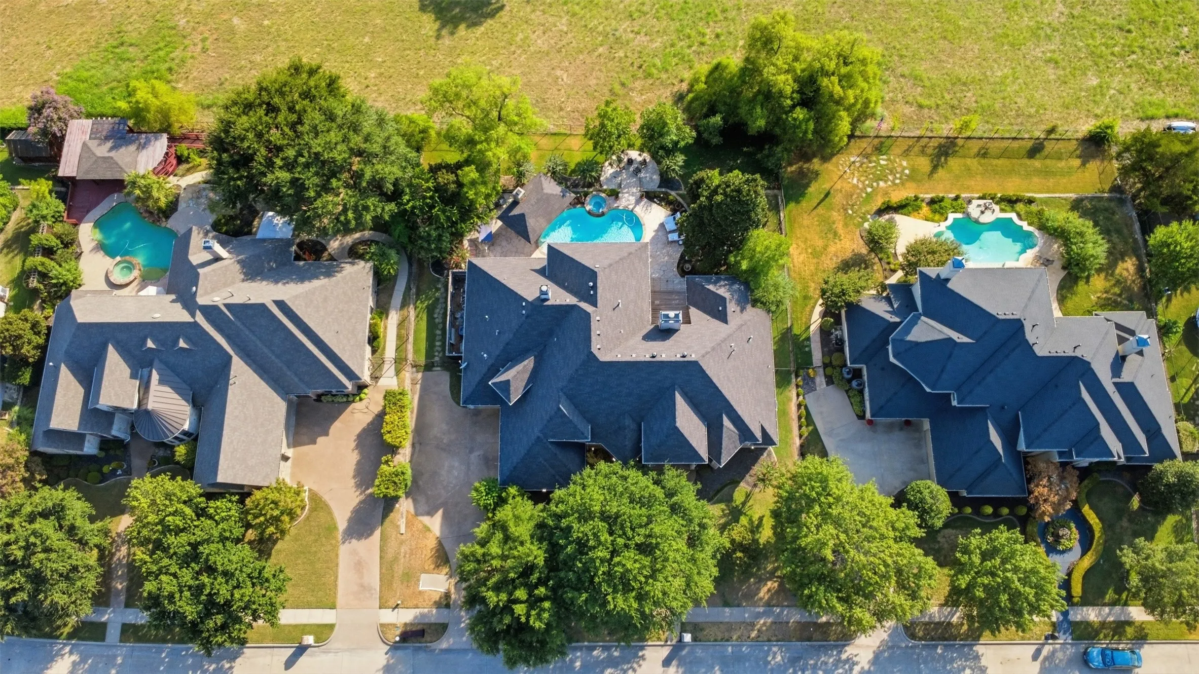 Paved driveways, mature trees, and swimming pools with integrated spas