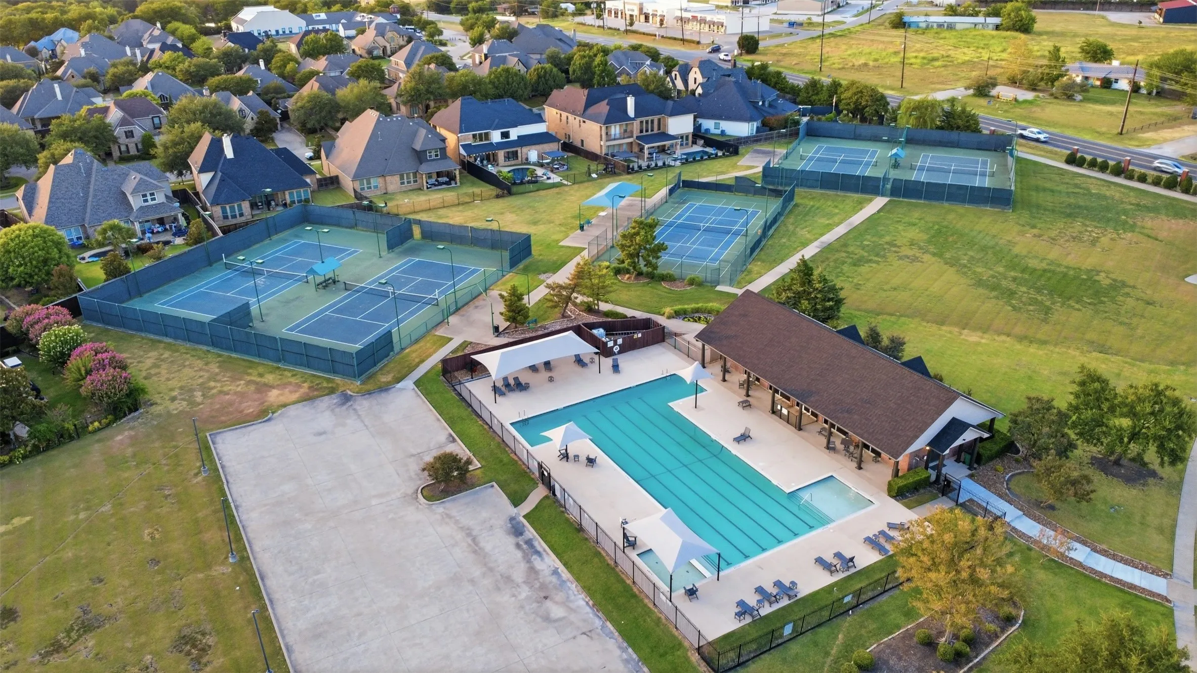 Community swimming pool with covered patio and multiple tennis courts