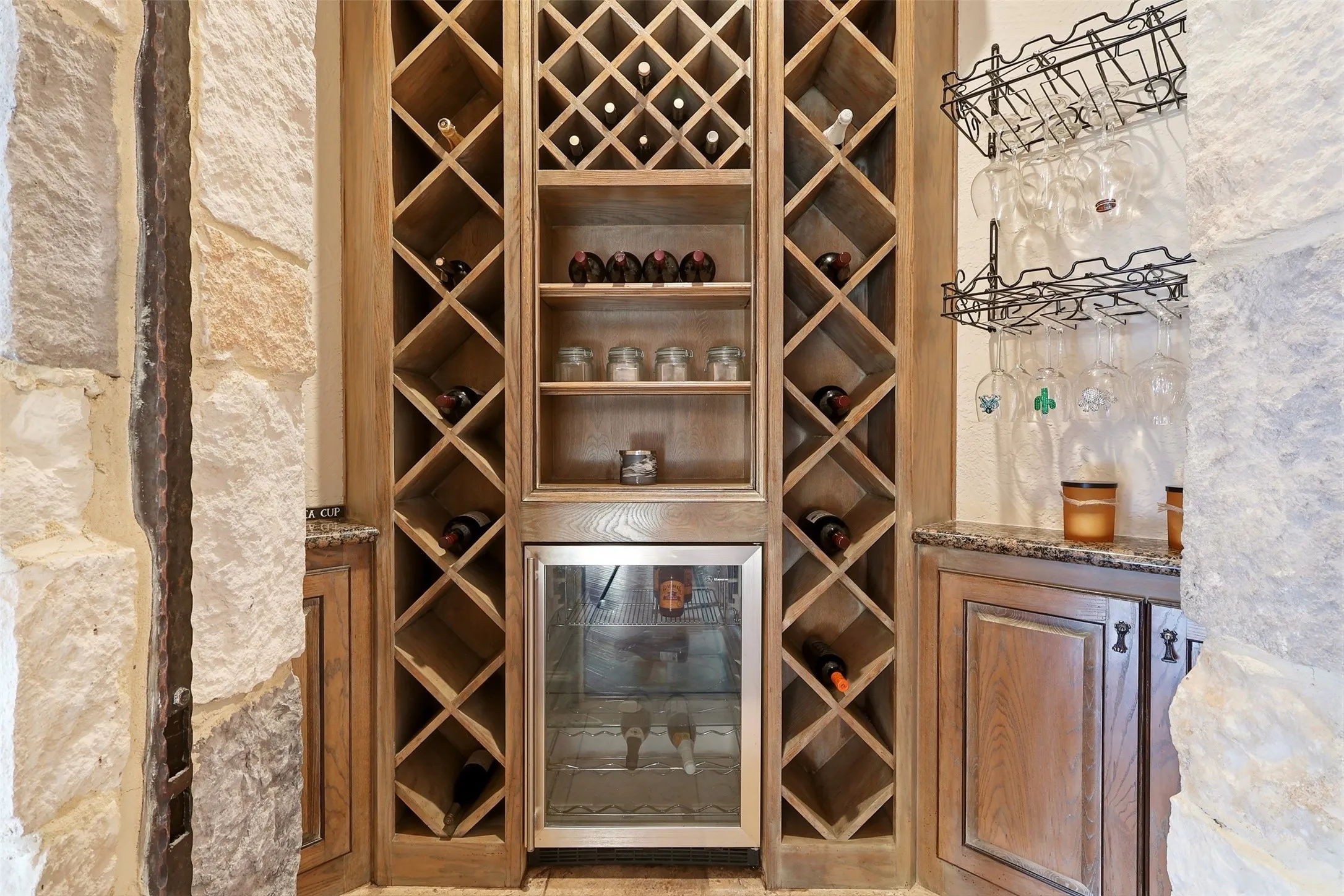 Built-in wine storage featuring wood-finish racks, integrated beverage refrigerator, and granite countertops