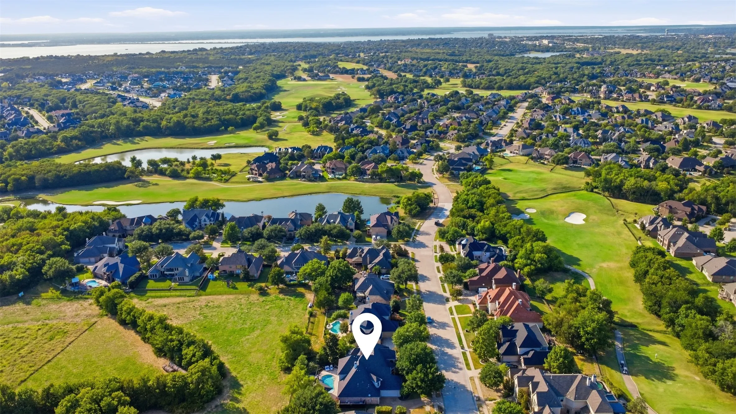 Expansive residential area with mature trees, green spaces, and a golf course and look at lake ray Hubbard in the horizon!