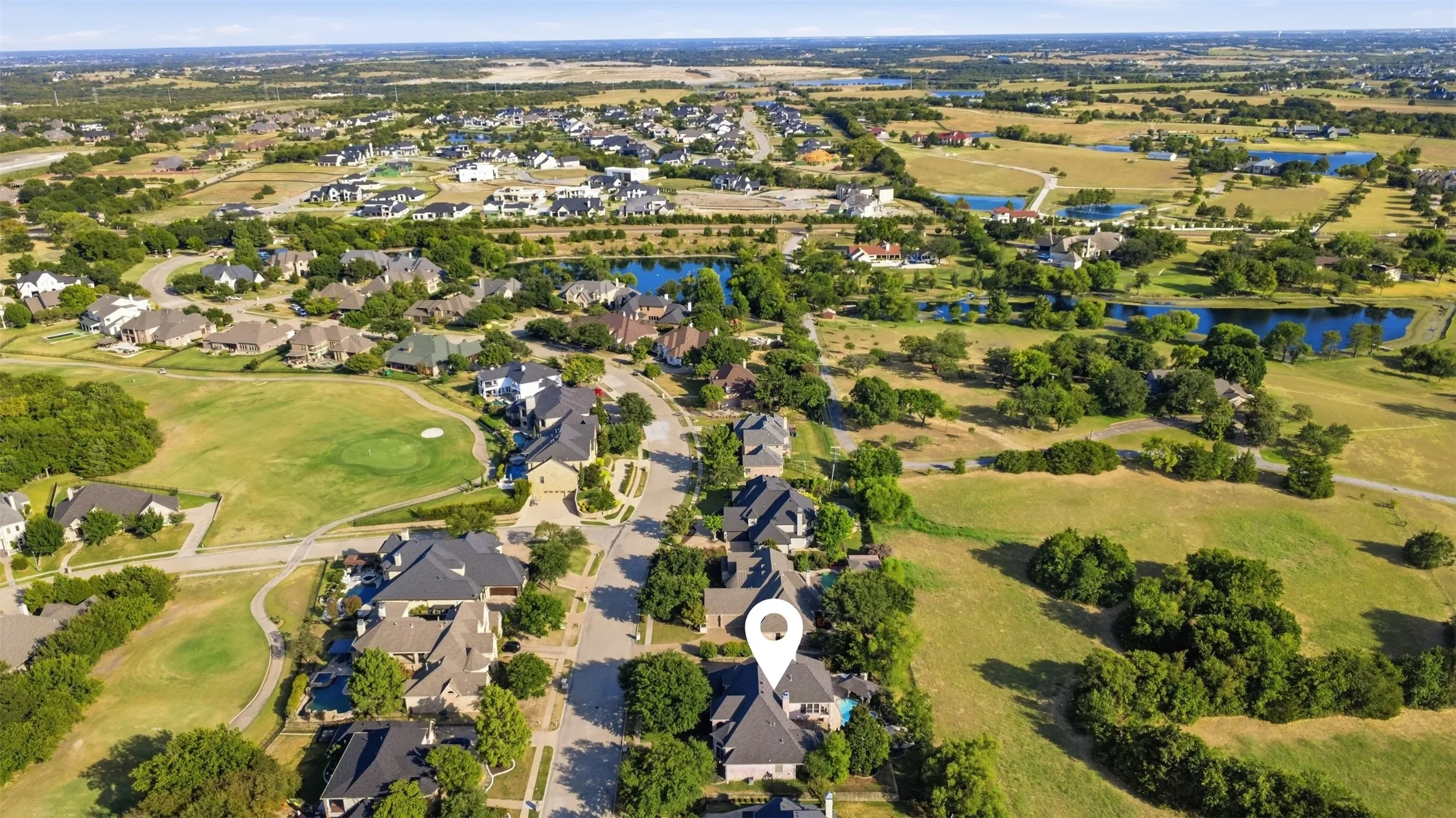 Aerial perspective of a residential neighborhood featuring established homes, mature trees, and a street network