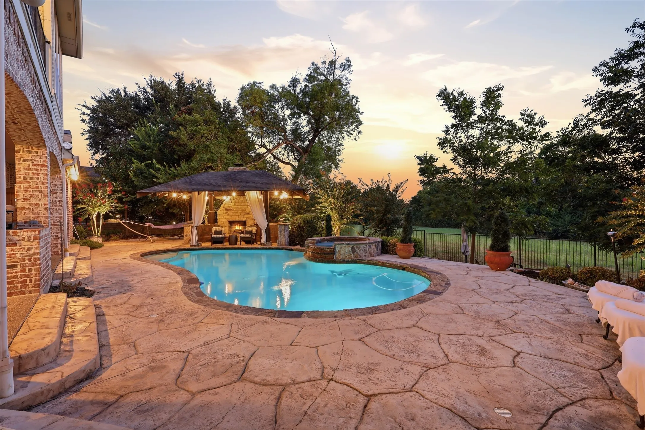 Freeform swimming pool with a stone coping and a hot tub