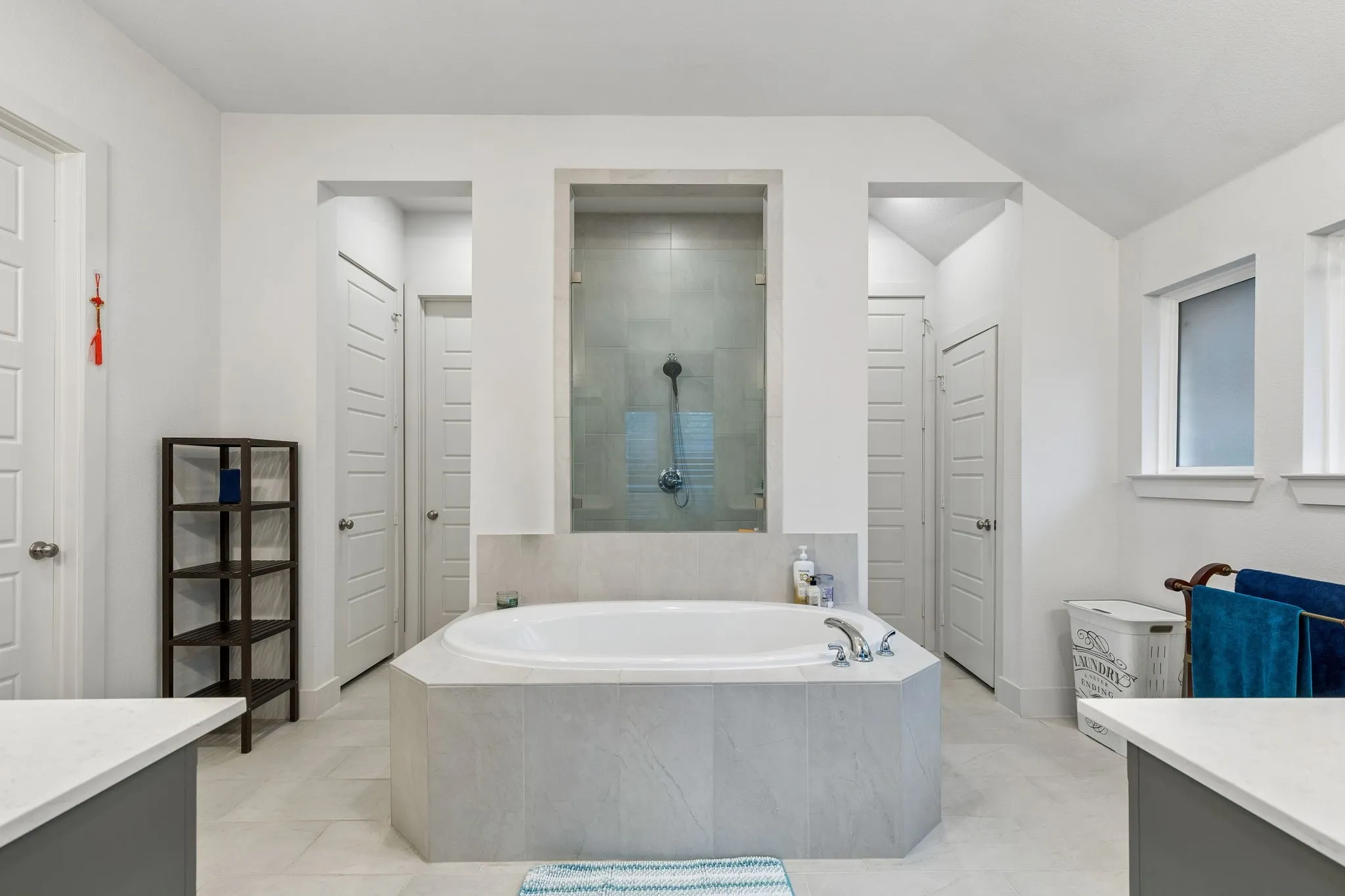 Bathroom featuring a built-in soaking tub with chrome fixtures, a tiled surround, and a glass-enclosed shower