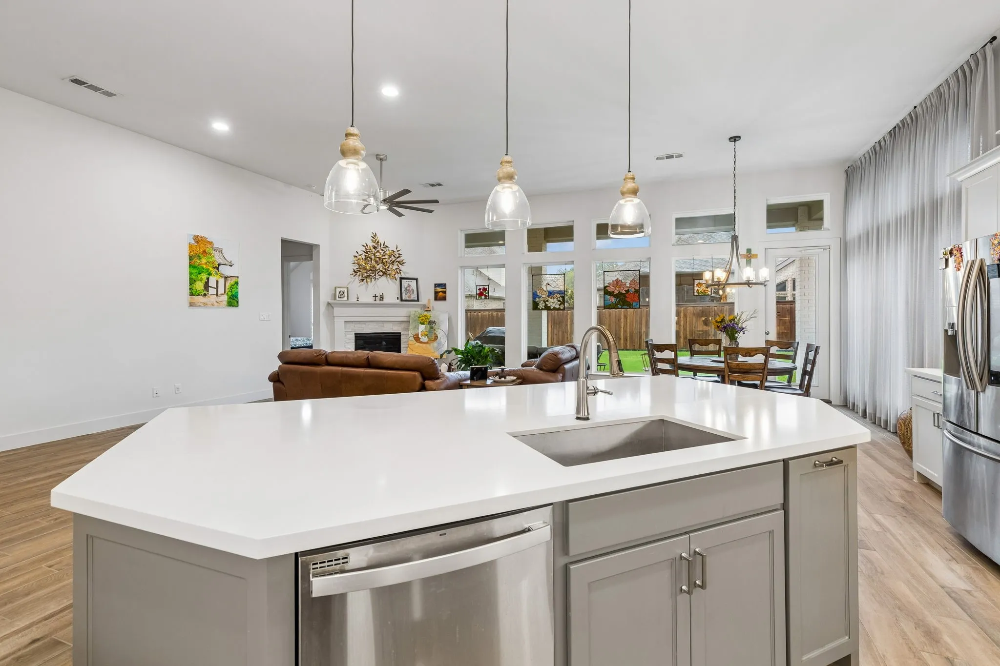 Kitchen island featuring a stainless steel sink, contemporary faucet, and integrated dishwasher