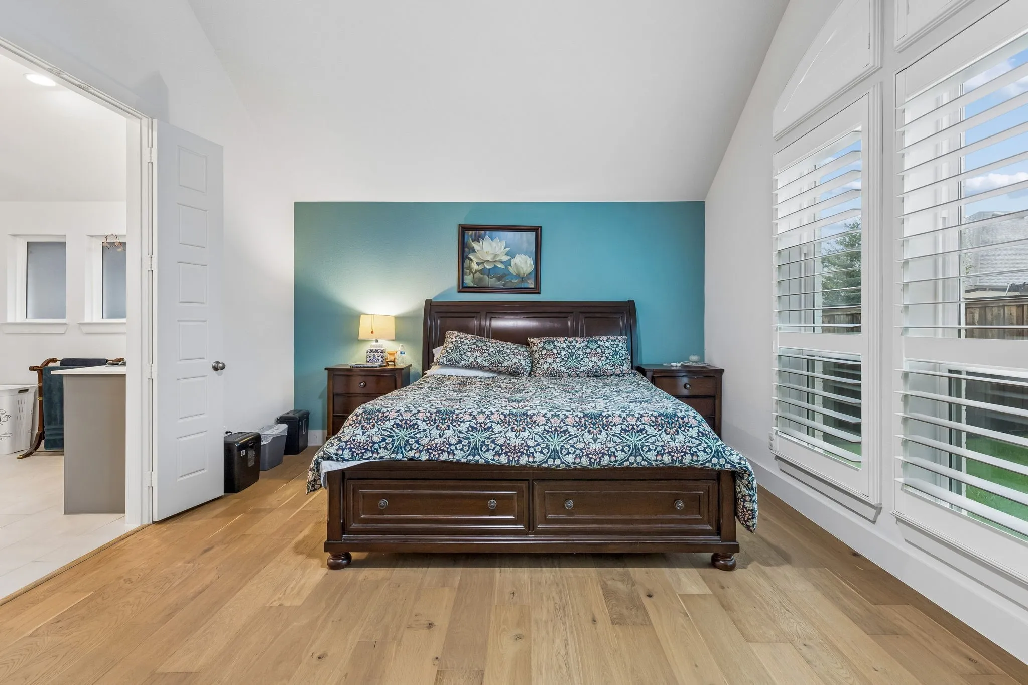 Vaulted ceiling room with wood-finish flooring