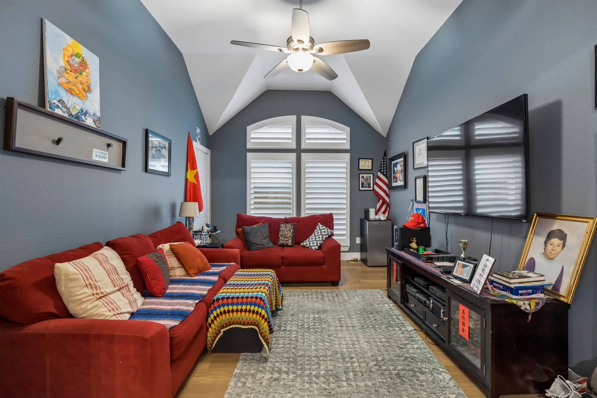 Vaulted ceiling room featuring wood-finish flooring