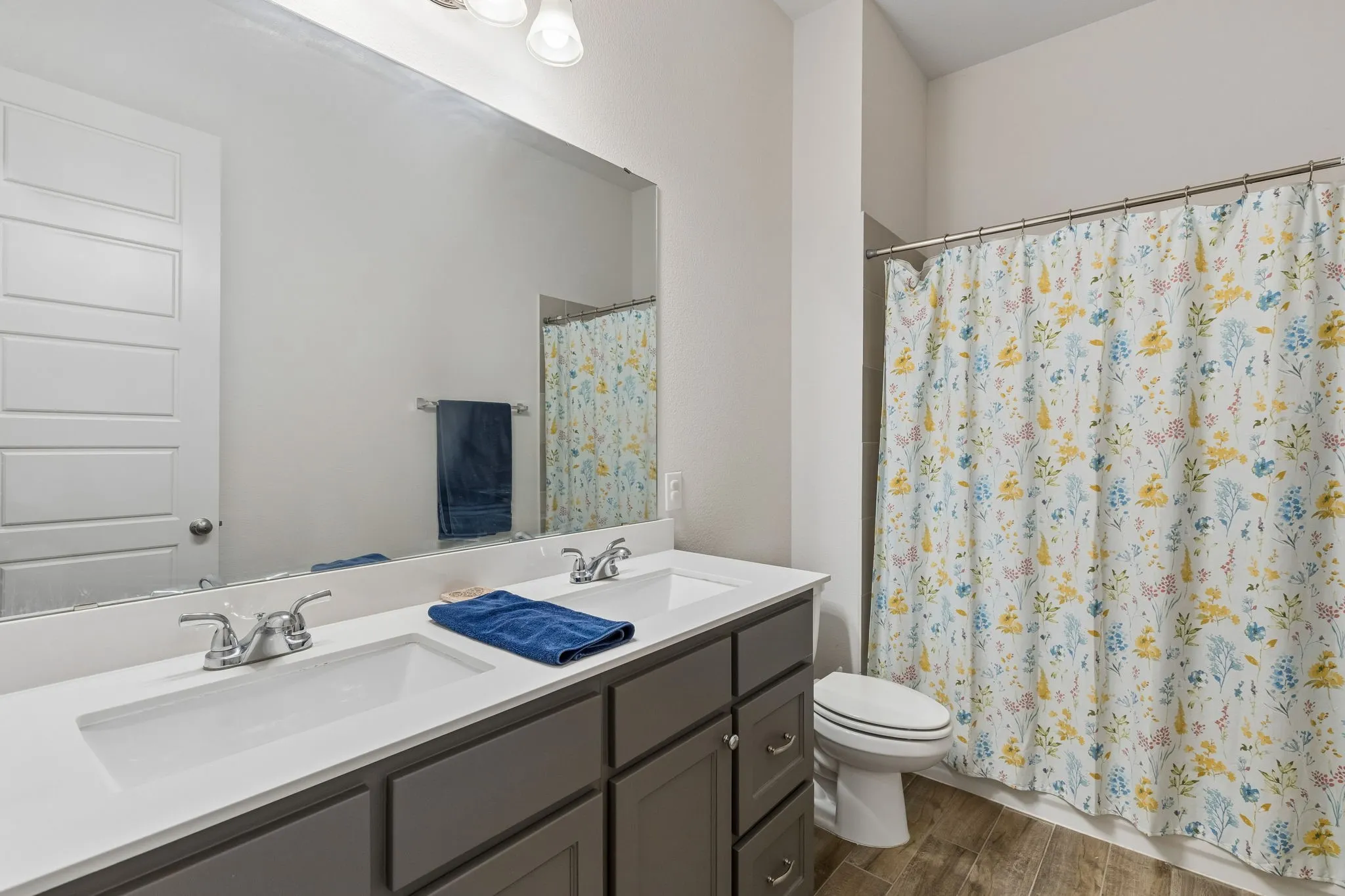 Bathroom featuring a double vanity with undermount sinks, a white countertop, and gray shaker-style cabinetry