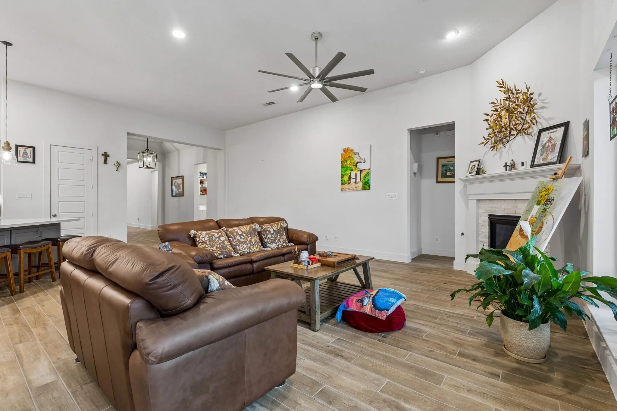 Spacious open-concept living area featuring wood-finish flooring, recessed lighting, and a modern ceiling fan