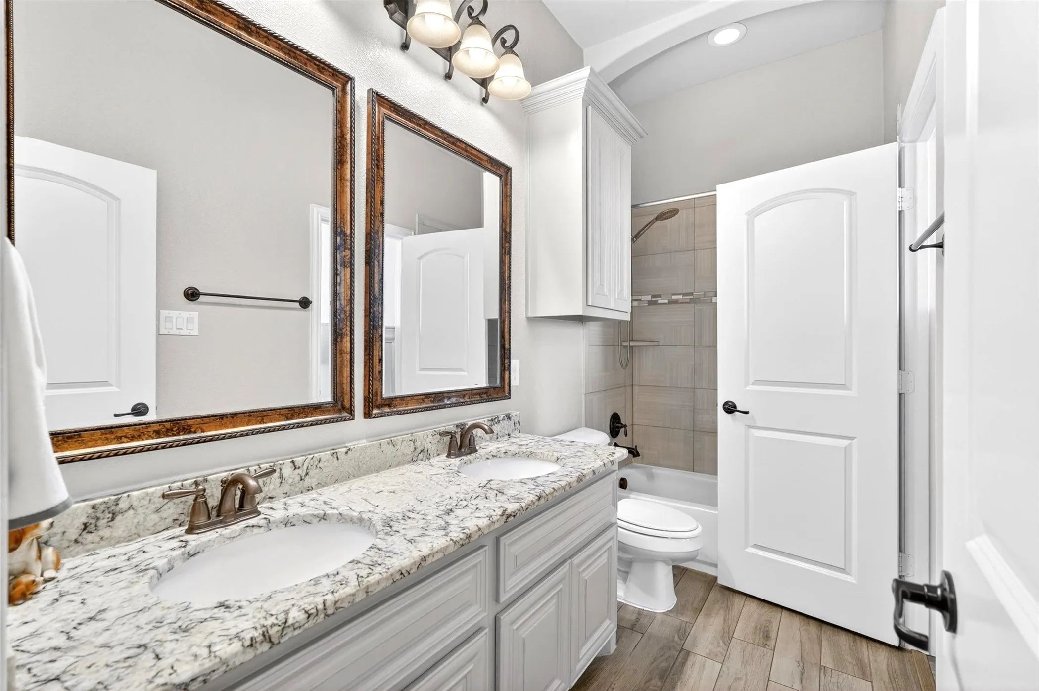 Secondary bathroom features dual-access doors — one from the hallway and one directly into the secondary bedroom, ideal for a private guest or kids' suite setup.