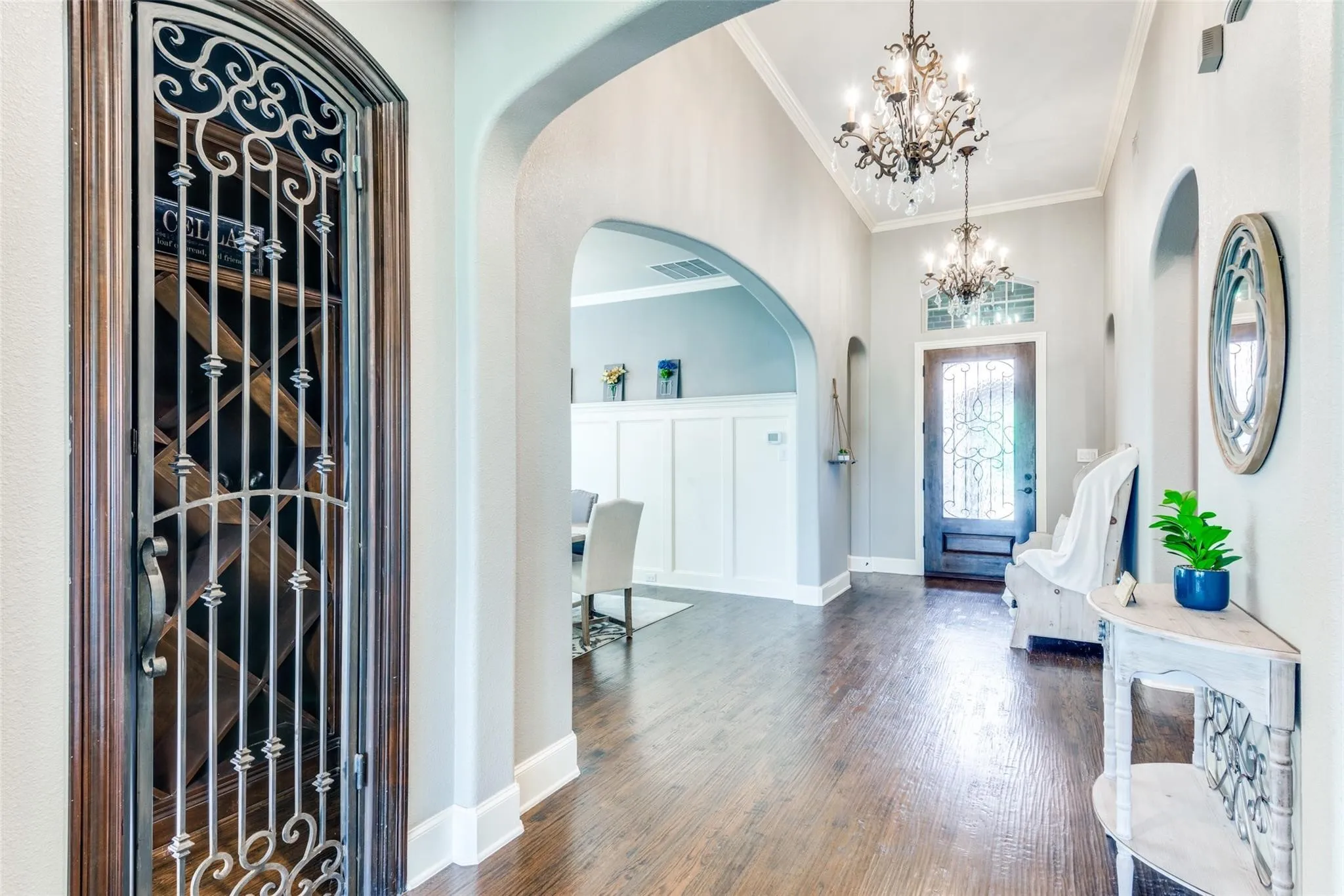 The grand open entry makes an unforgettable first impression with elegant arched passageways that create a seamless flow throughout the home. Just off the entry, a stunning wine closet with decorative iron doors offers the perfect blend of luxury and functionality — an eye-catching feature ideal for entertaining and showcasing your collection in style.