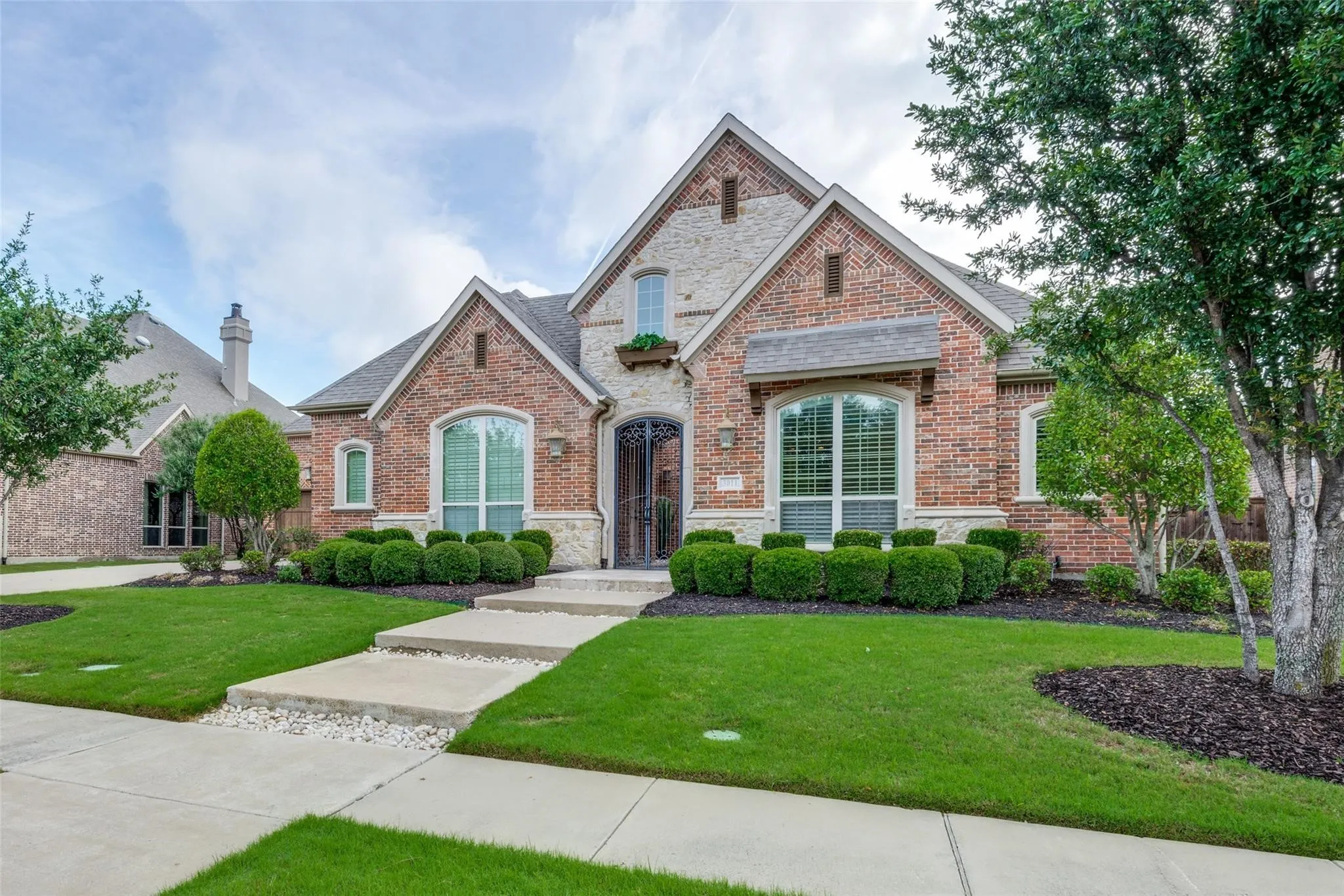 This beautifully crafted brick and stone estate showcases timeless architecture, manicured landscaping, and exceptional curb appeal from the moment you arrive.
