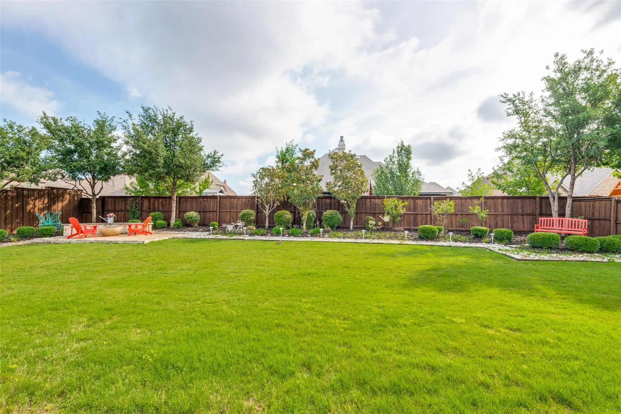 This massive backyard is a rare find, offering an incredible amount of usable green space within the exclusive gated section of The Tribute. The expansive lawn creates endless possibilities for outdoor living. Beautifully landscaped with mature trees, manicured shrubs, and decorative stone borders, the yard provides a picturesque setting that feels both private and serene.