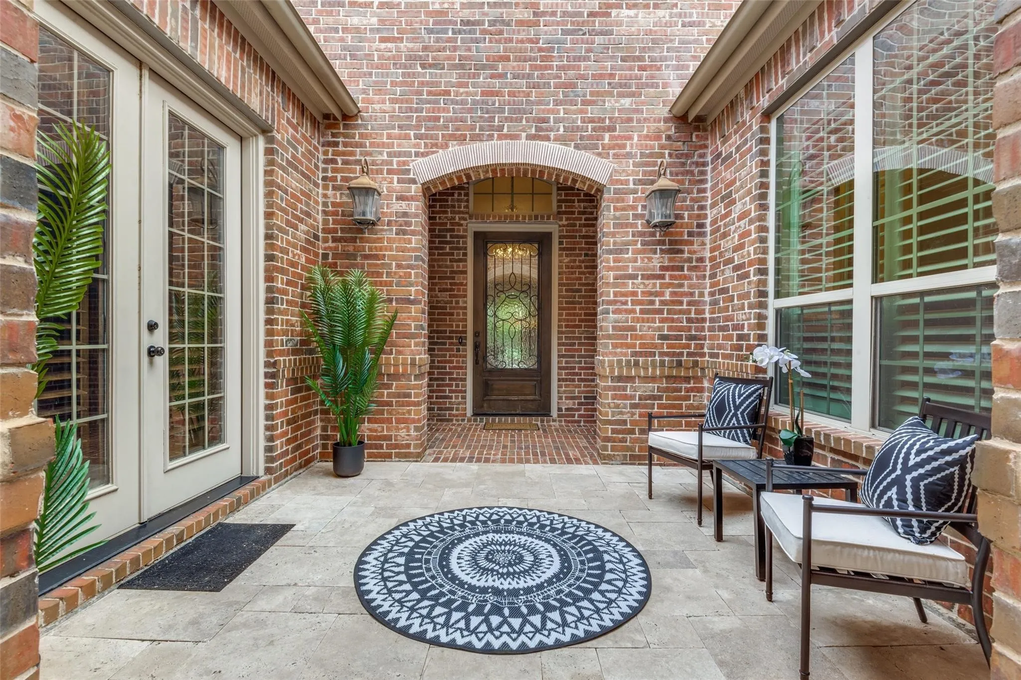 Step through the private gated courtyard and into a warm, inviting retreat designed for both elegance and tranquility with a spacious covered sitting area perfect for morning coffee or evening conversations