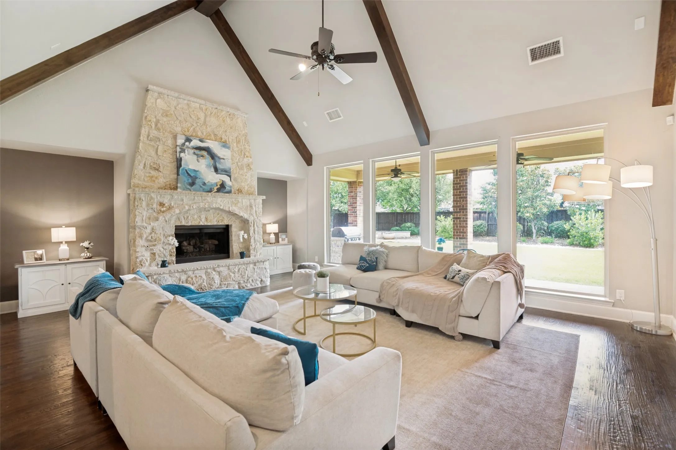 Expansive windows flood the room with natural light while offering seamless views of the outdoor living area, creating the perfect blend of indoor-outdoor living.