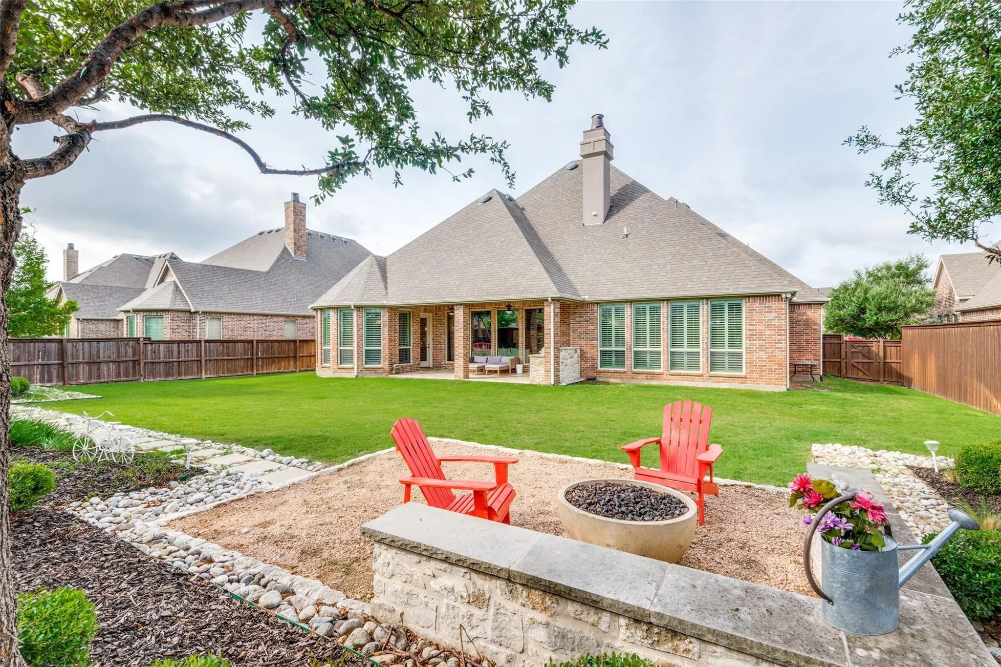 One of the most desirable features of this home is the incredible outdoor space, offering a vast stretch of lush green lawn with endless possibilities for recreation, a future pool, or simply enjoying the privacy and serenity of your surroundings. Beautiful landscaping, mature trees, and thoughtfully designed stone pathways create a picturesque setting that feels like your own private park.At the heart of the yard, a charming gathering area invites you to cozy up beside the gas fire pit beneath the Texas sky.