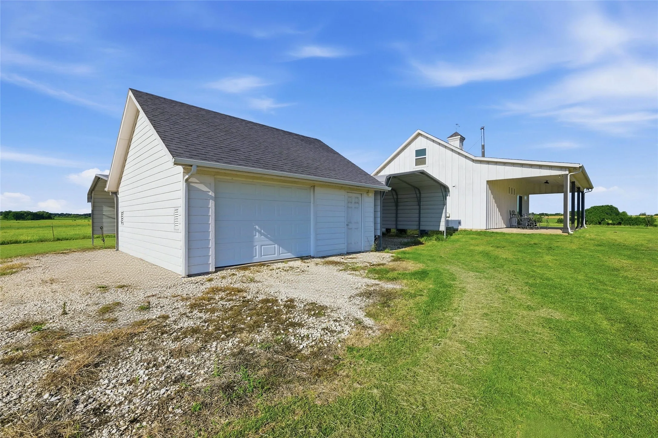 Back of home with patio and garage beside home