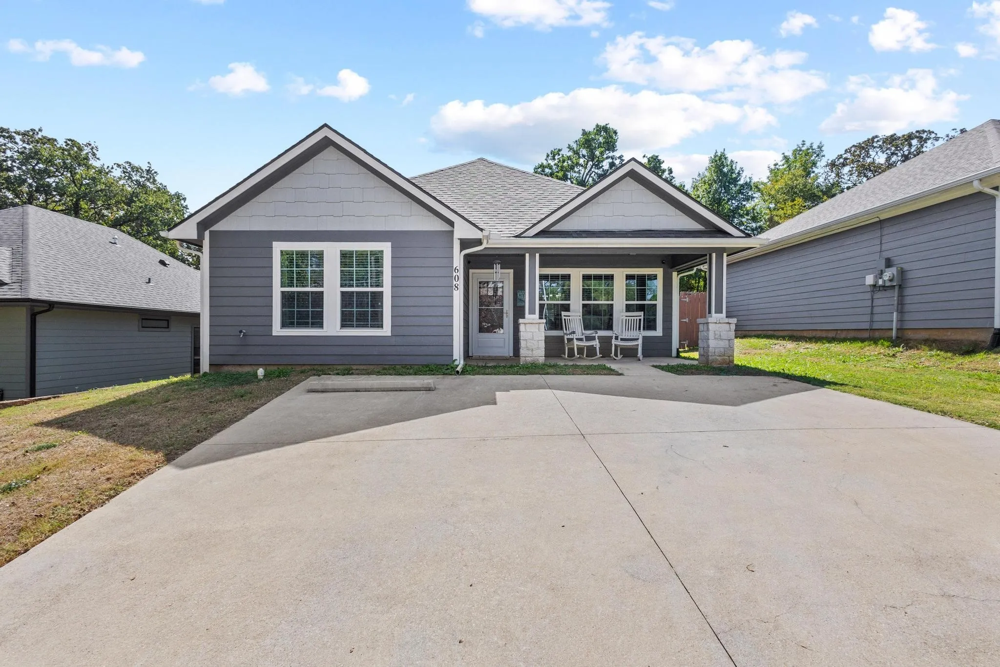 Contemporary single-story residence with a gray siding exterior and white trim accents