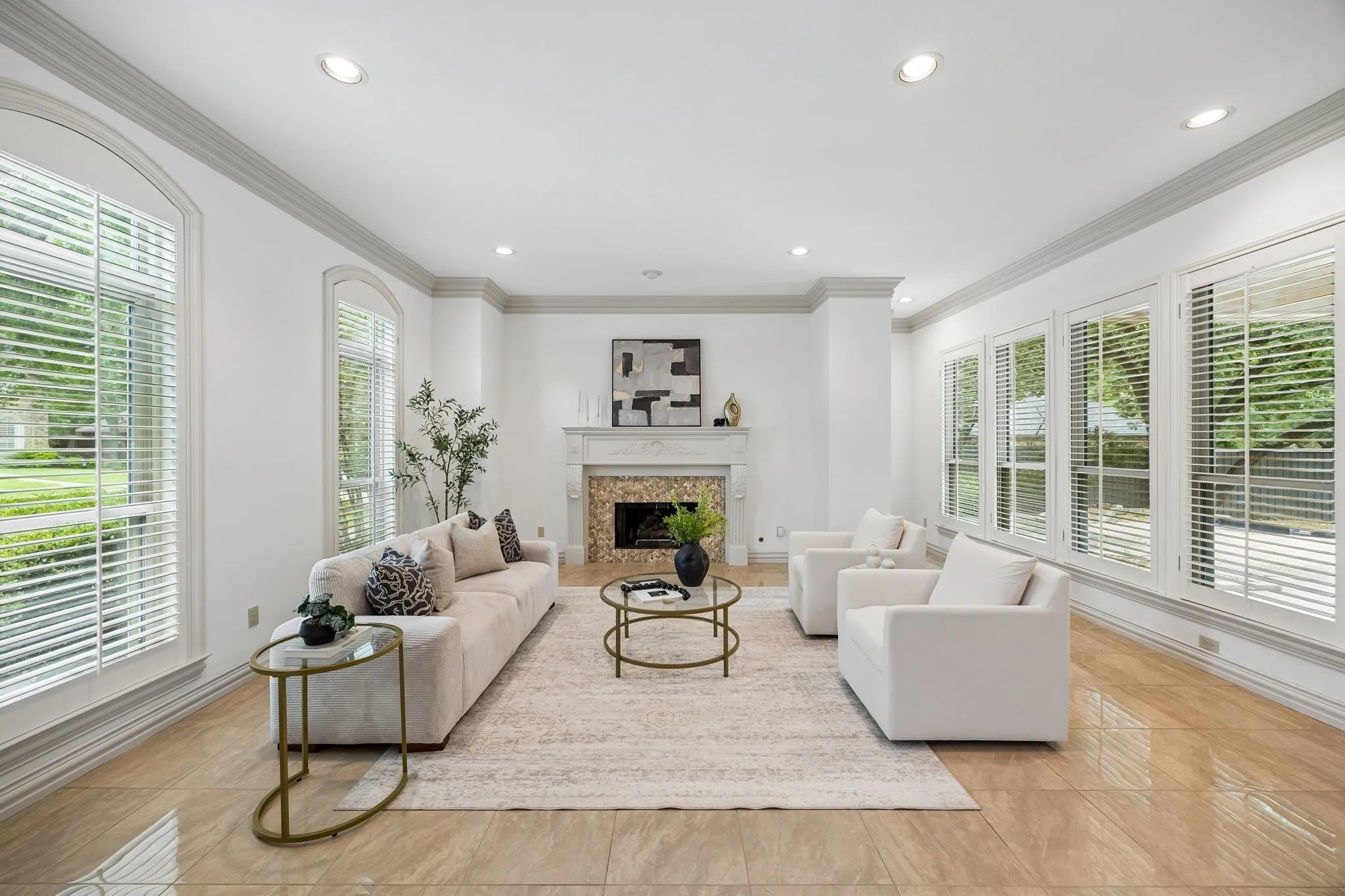 Spacious living area featuring large windows, crown molding, recessed lighting, and tile flooring