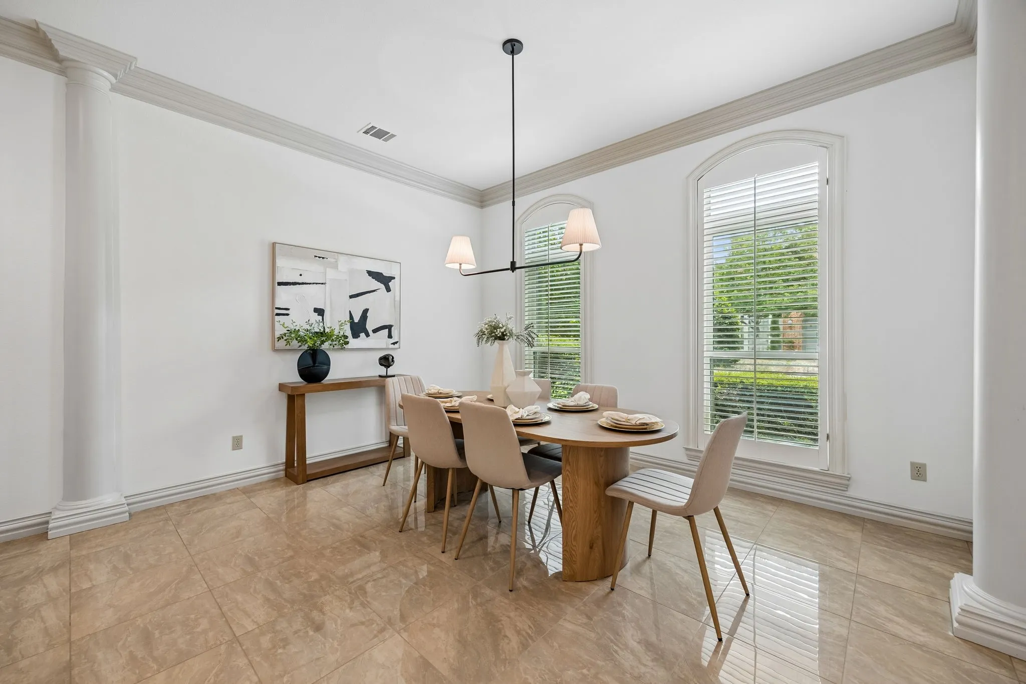 Spacious room featuring polished tile flooring, decorative baseboards, and elegant crown molding
