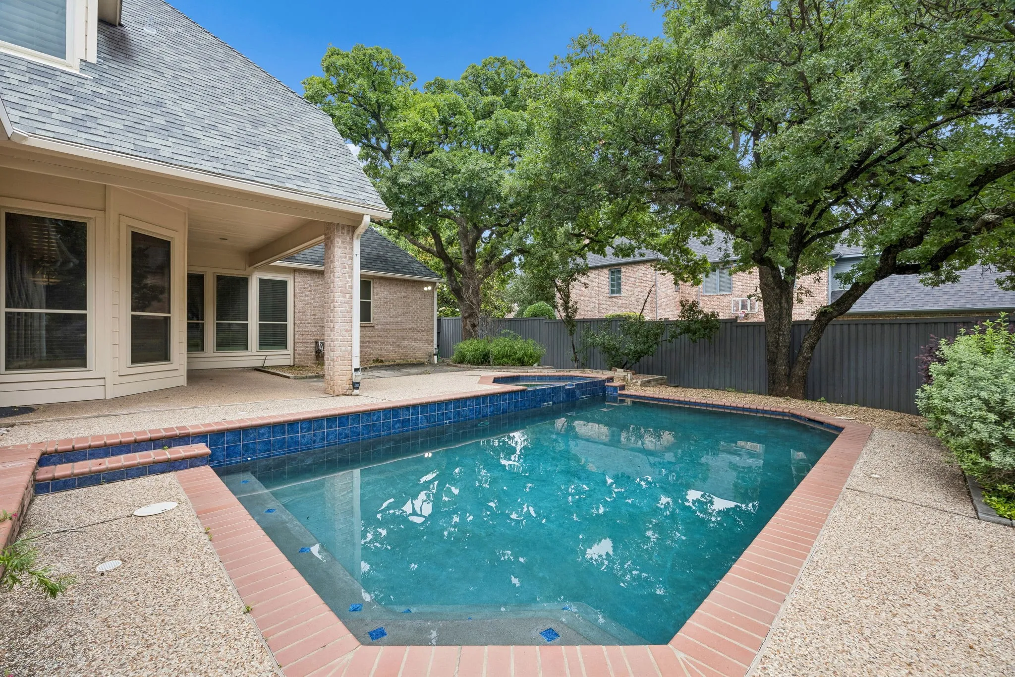 Swimming pool with blue tile accents and brick coping