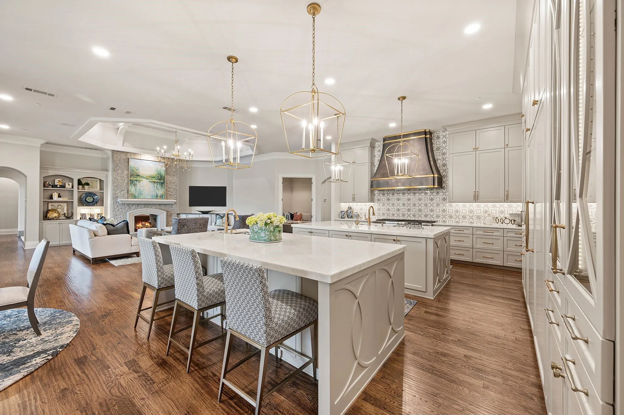 This stunning, redesigned kitchen boasts double quartz islands, dual-fuel range, oversized built-in refrigerator-freezer & lovely, lighted display cabinetry.