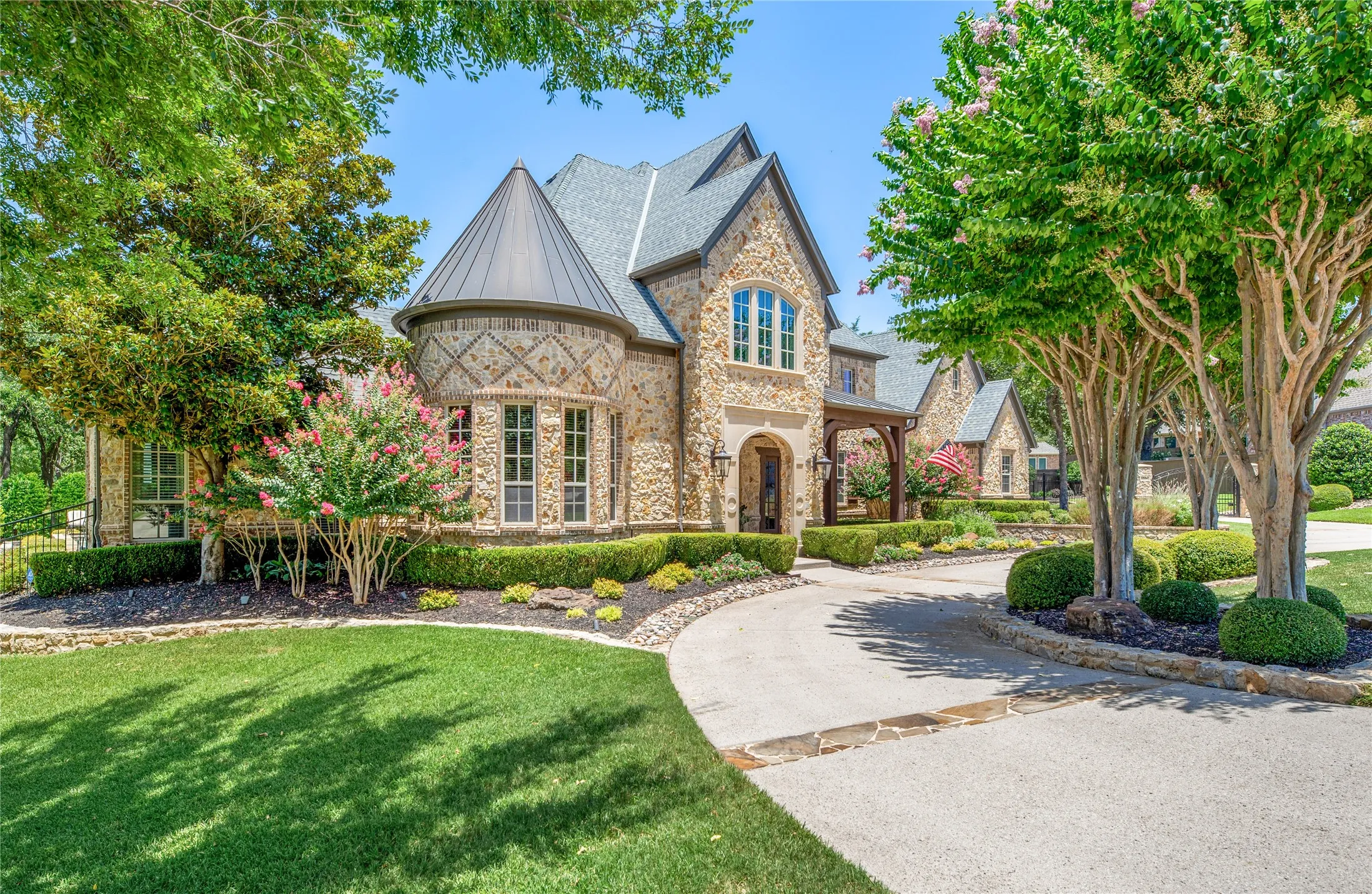 Impeccable landscaping and colorful plantings render lovely curb appeal along with quality windows and a custom iron & glass front door.