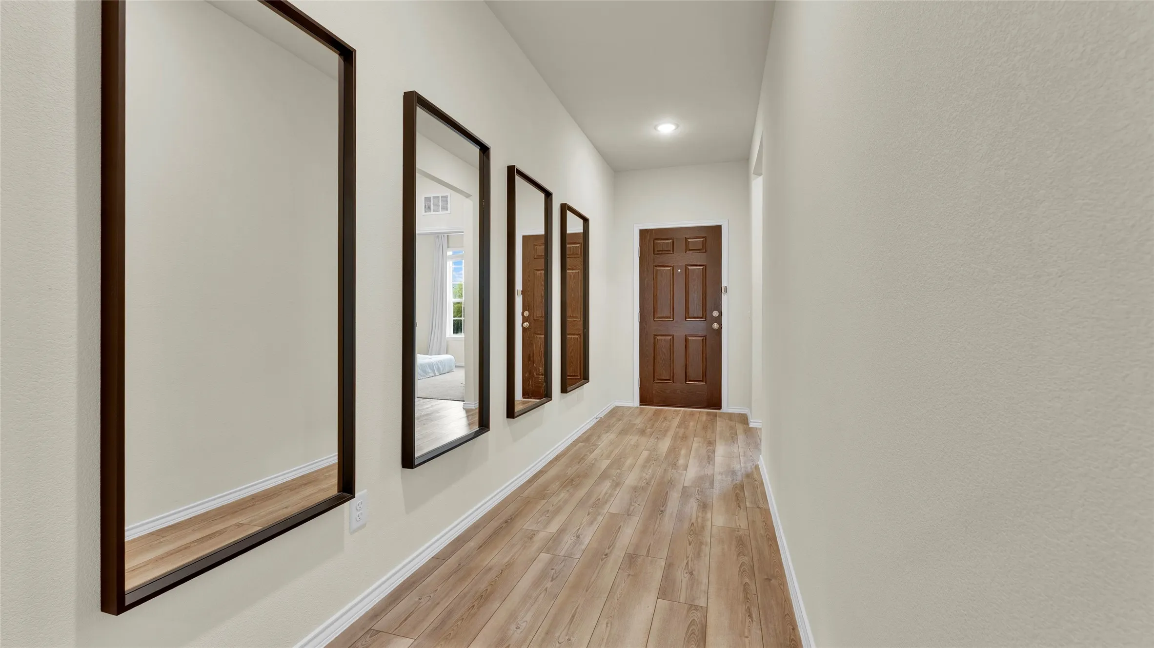 Entryway featuring wood-finish flooring, light neutral wall tones, and a paneled entry door