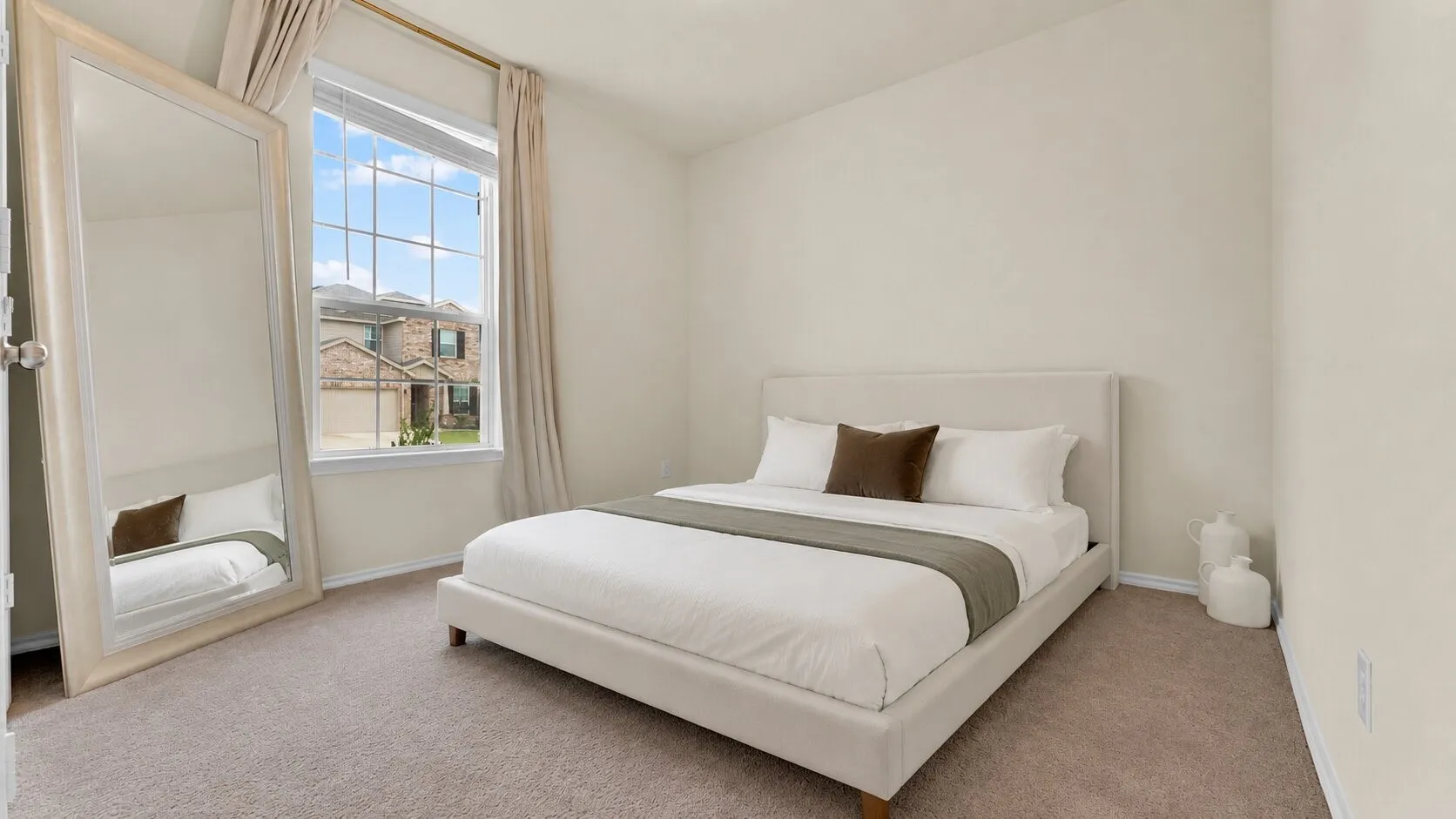 Carpeted room featuring a large window with grid panes, neutral wall paint, and white baseboards