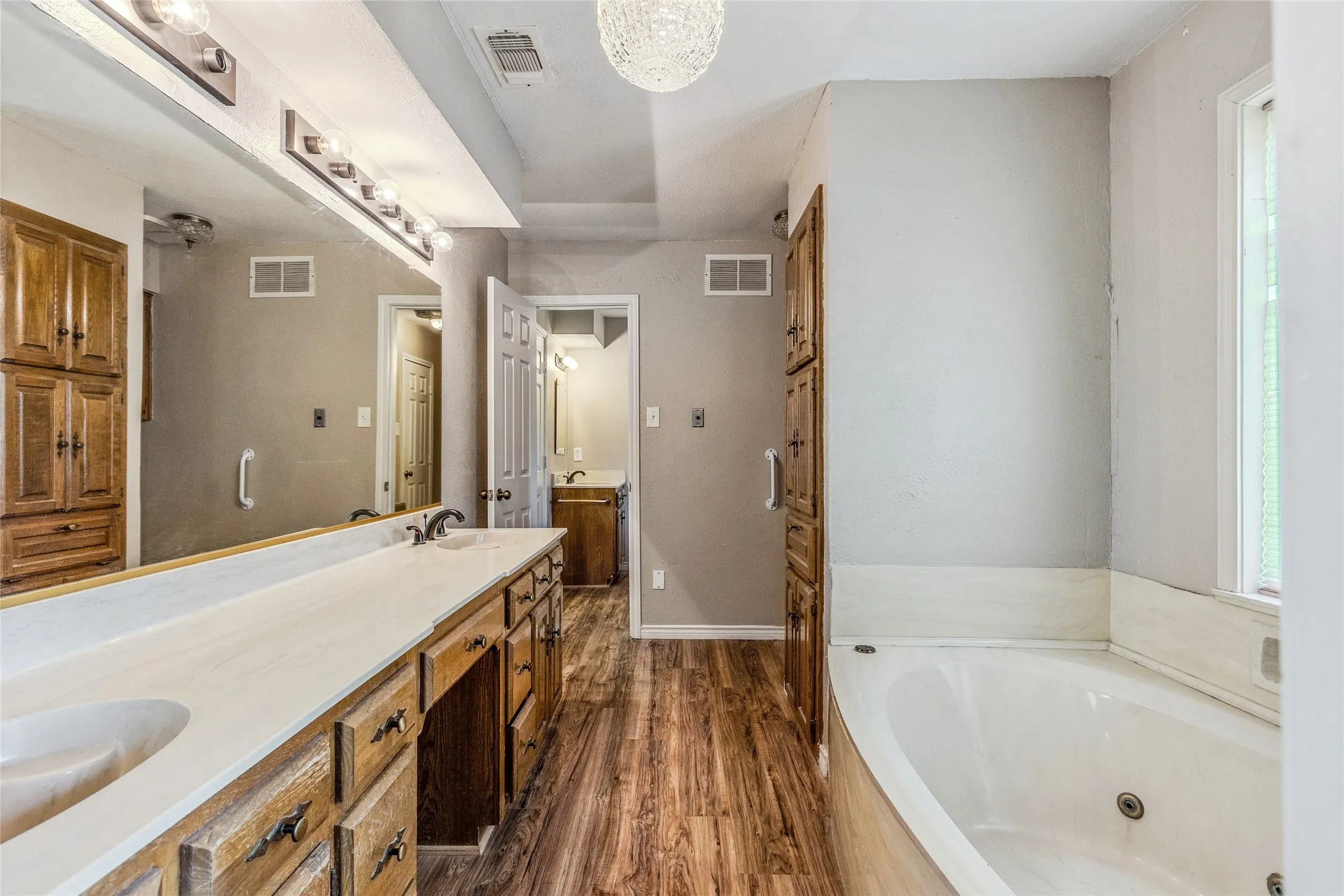 Bathroom featuring an extended double vanity with wood cabinetry and dual sinks