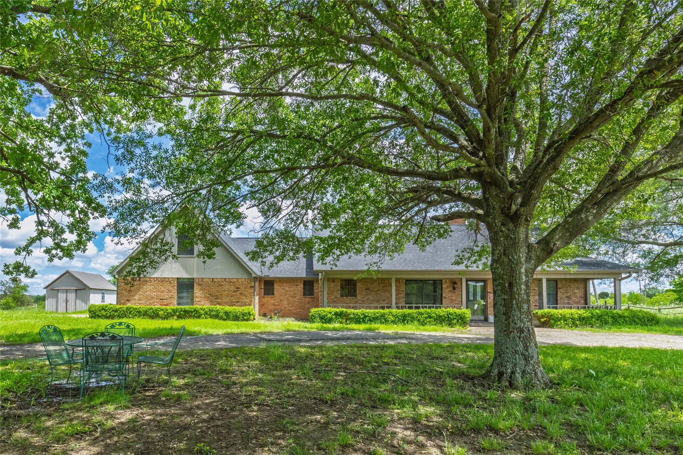 Expansive front yard featuring mature trees and a manicured lawn