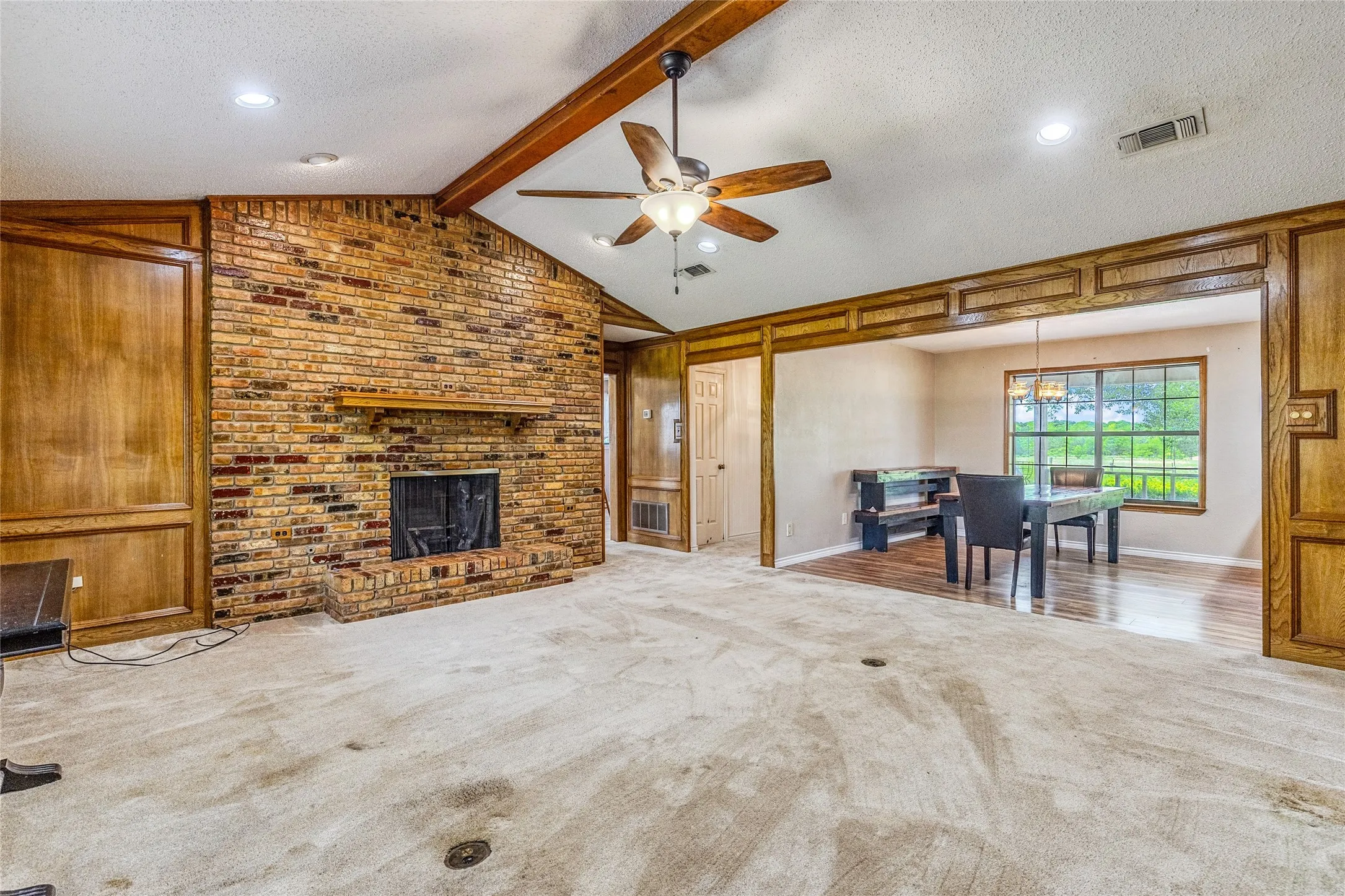 Vaulted ceiling with exposed wood beam, recessed lighting, and a ceiling fan