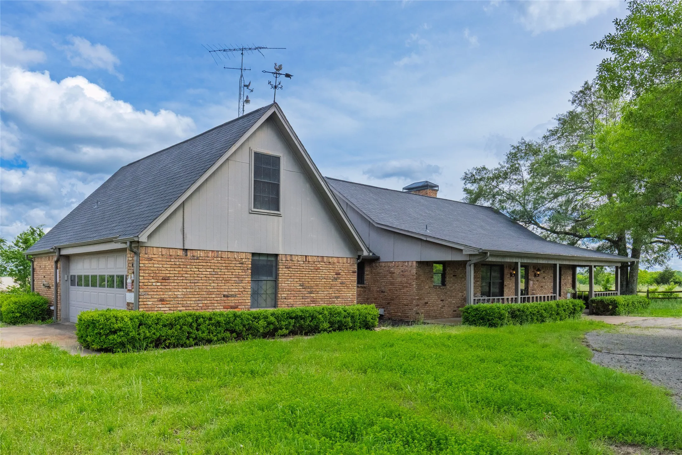 Brick exterior with a gabled roofline, attached garage, and a covered porch