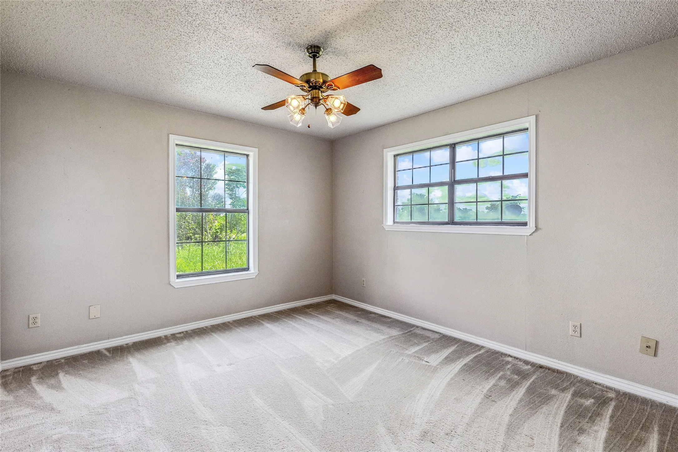 Light gray wall paint complemented by an overhead ceiling fan with light fixture