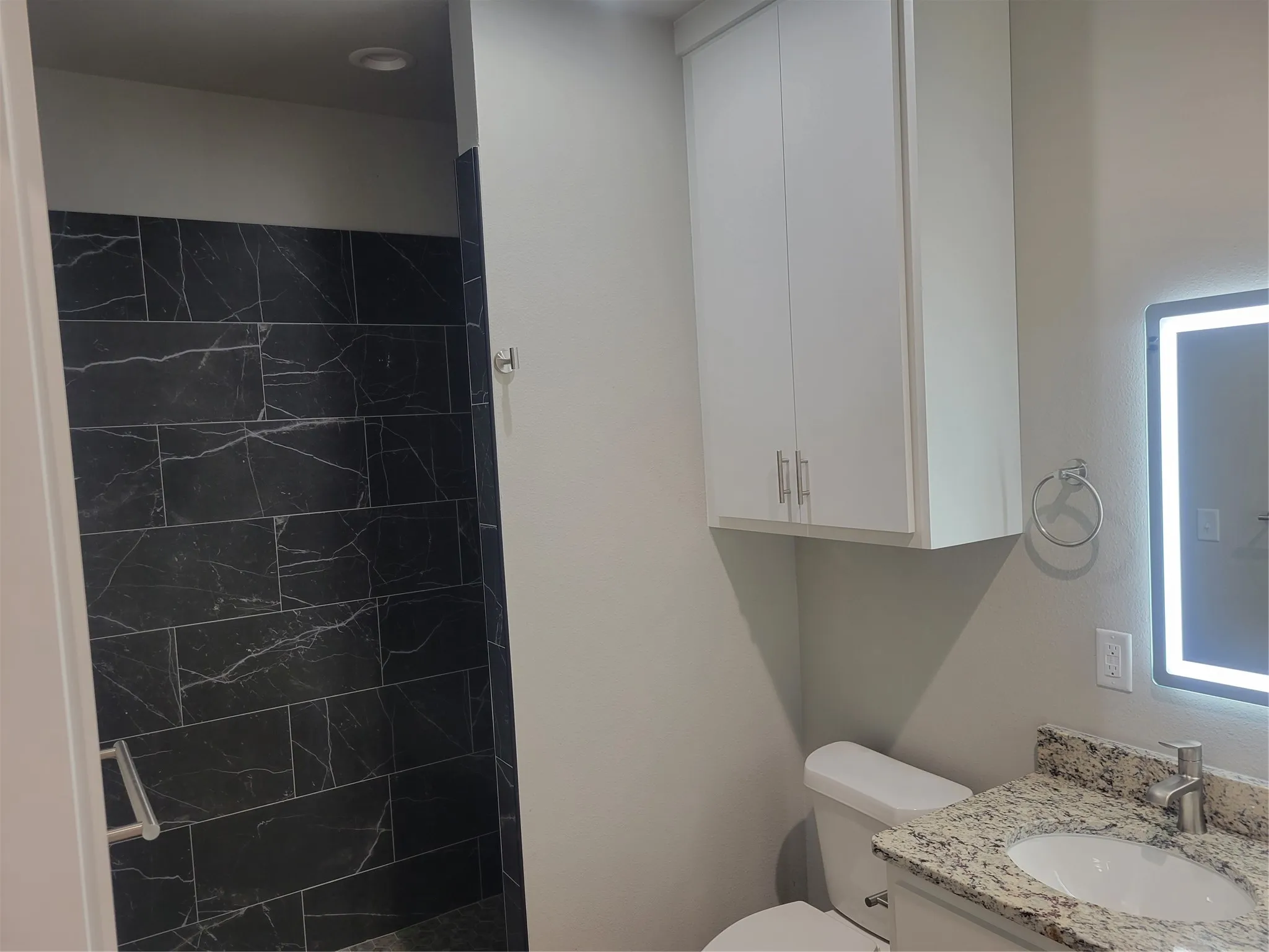 Bathroom featuring a vanity with granite countertop, undermount sink, and chrome faucet