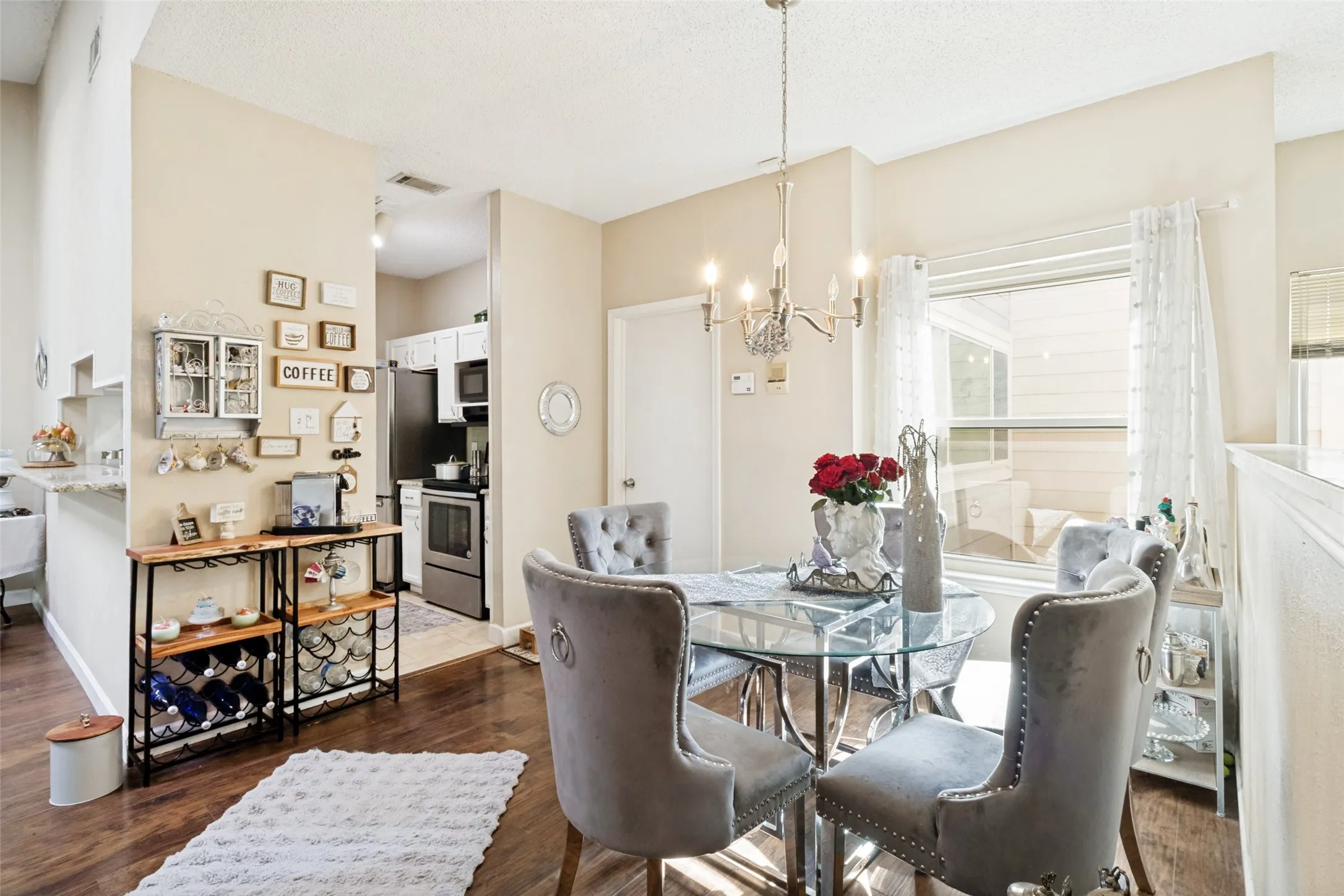 Dining area featuring wood-finish flooring, a contemporary chandelier, and a large window