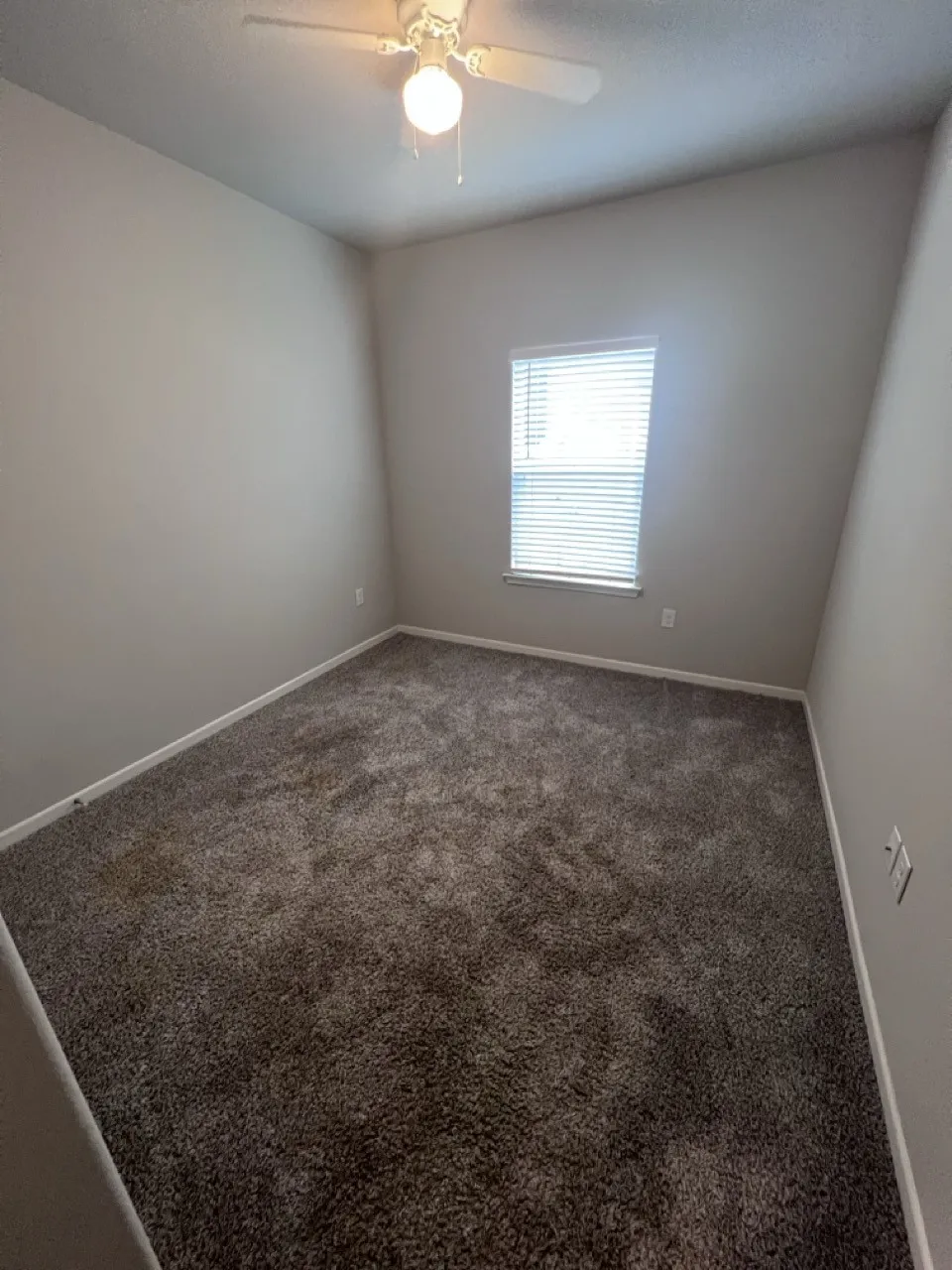 Neutral tone wall paint with a window featuring horizontal blinds