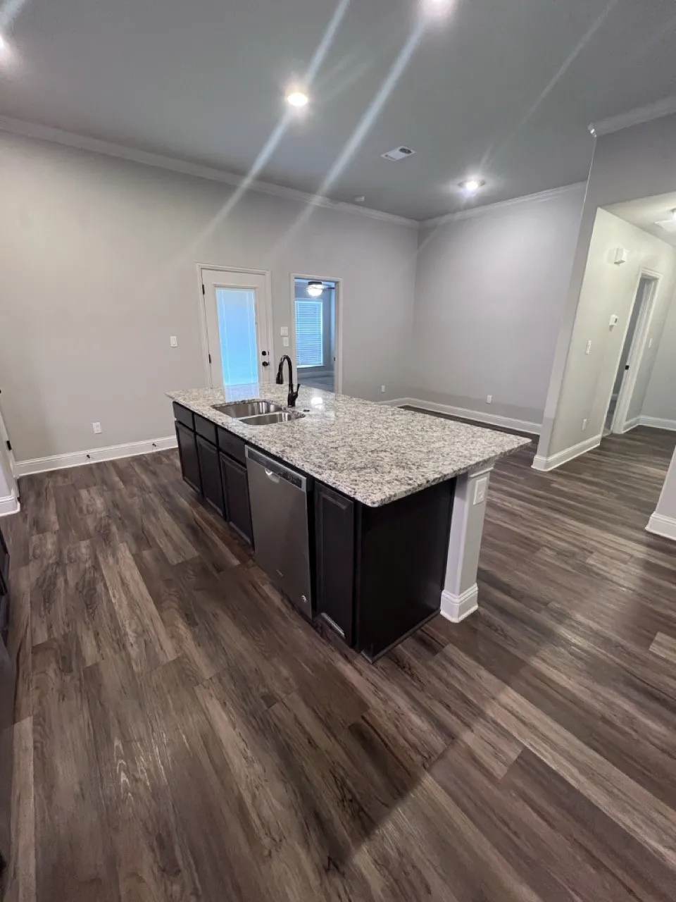 Kitchen island featuring a stainless steel sink, black faucet, and light-colored countertop