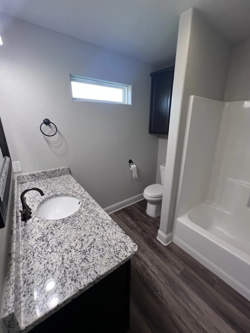 Bathroom featuring a spacious vanity with a speckled countertop and integrated oval sink